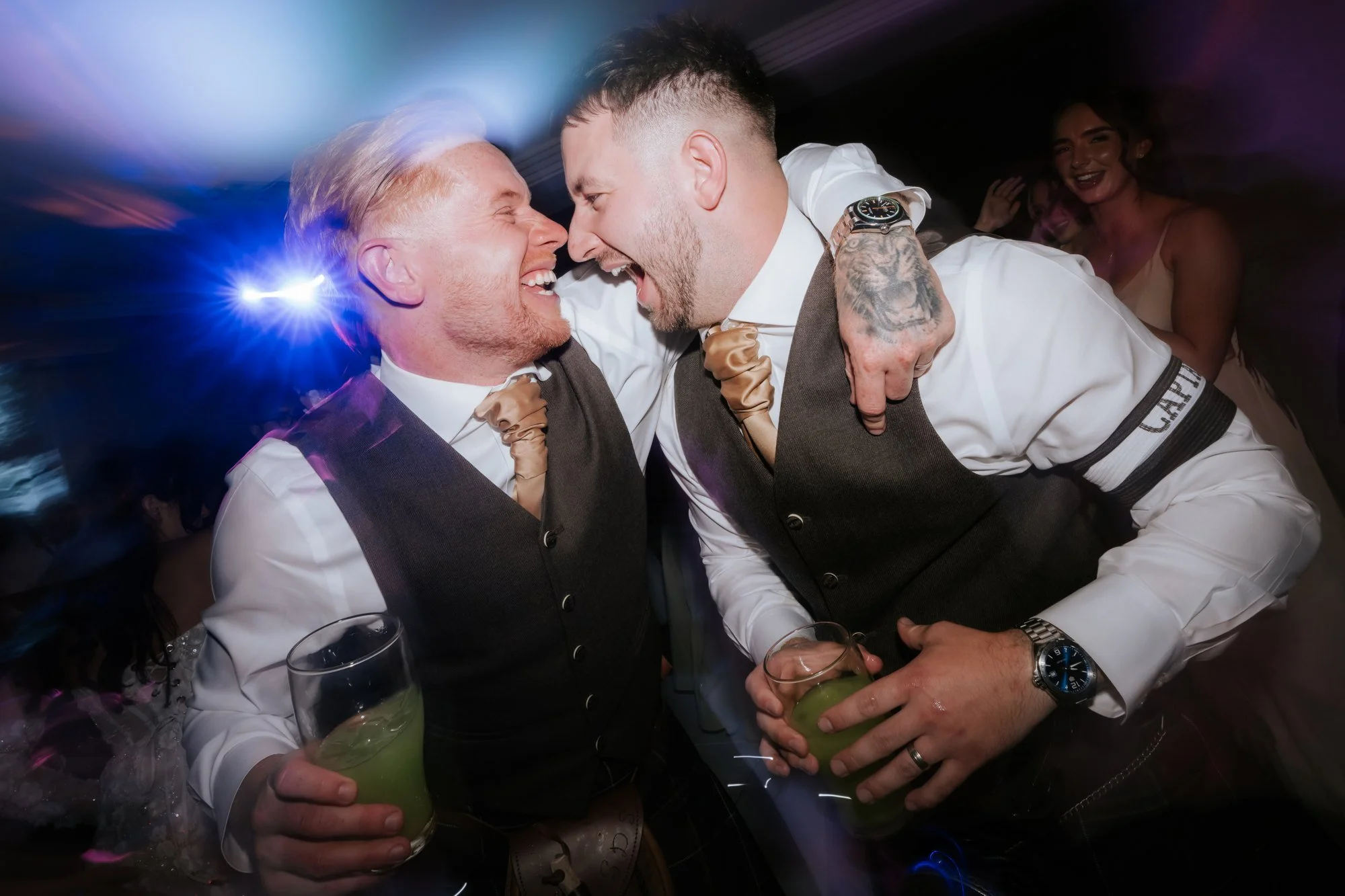 Scott and a friend laughing together under blue dance-floor lights at Glenbervie House.