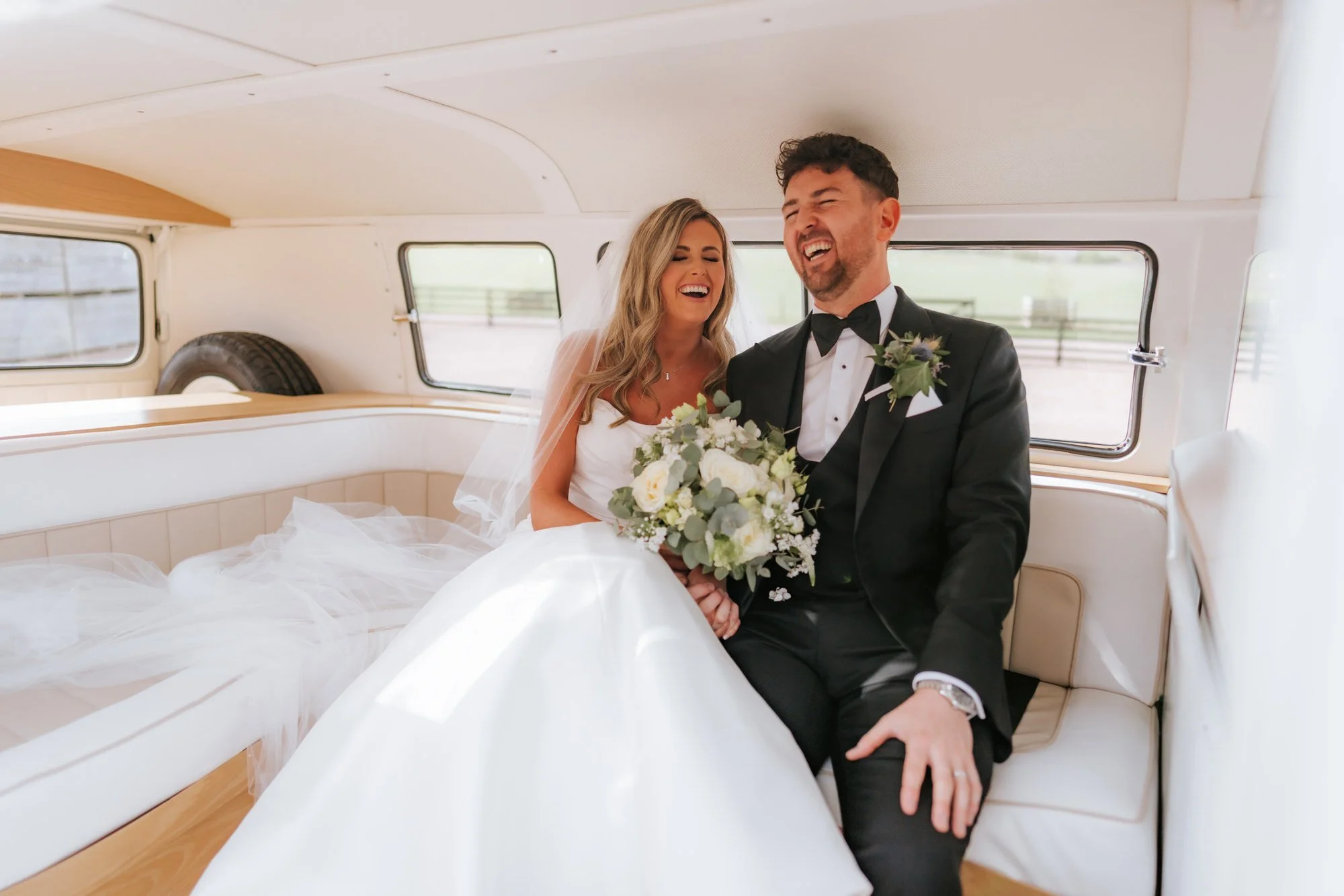 Natalie and Jamie laughing inside a camper van