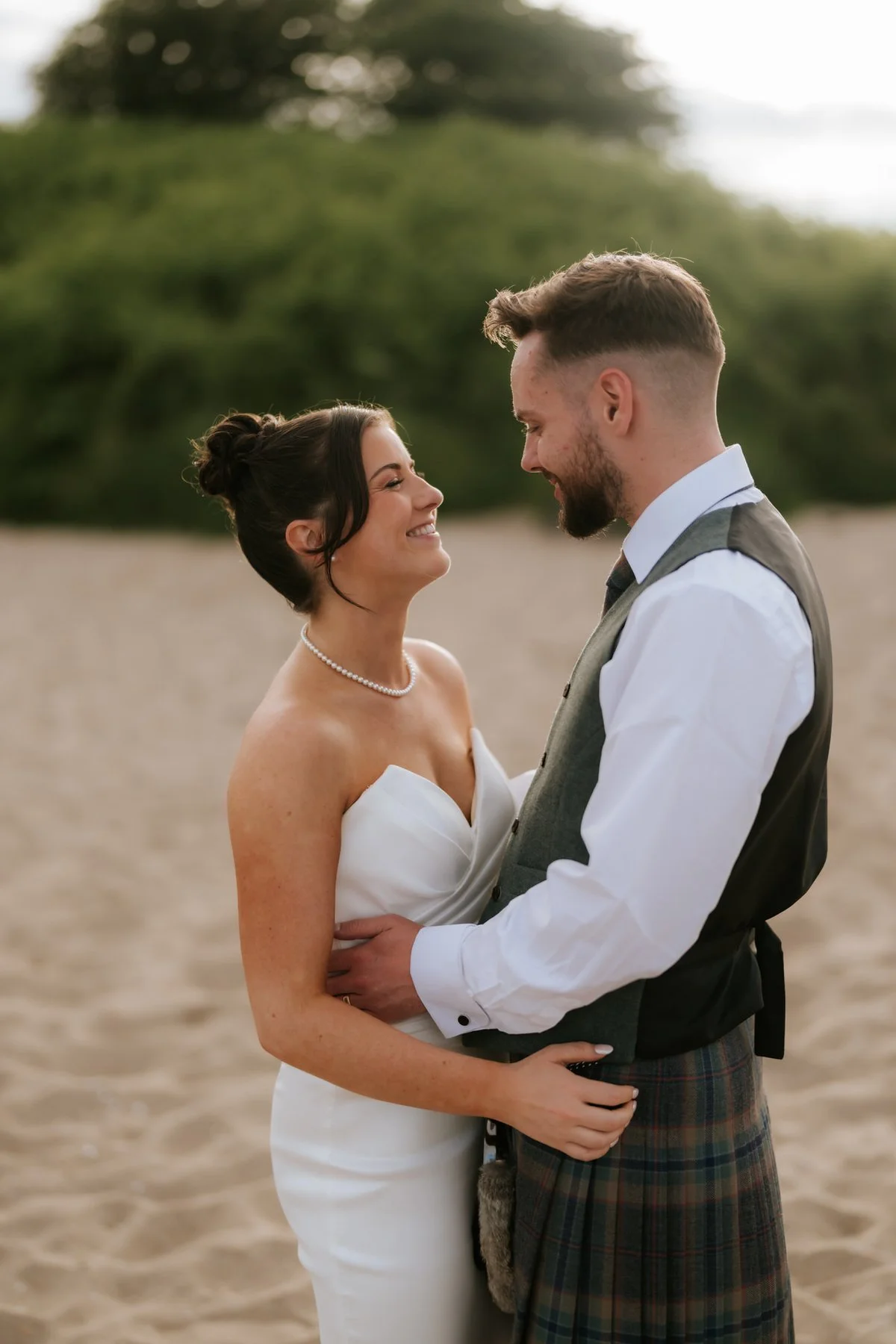Lois and Dougie smiling at one another during a quiet moment on the beach.