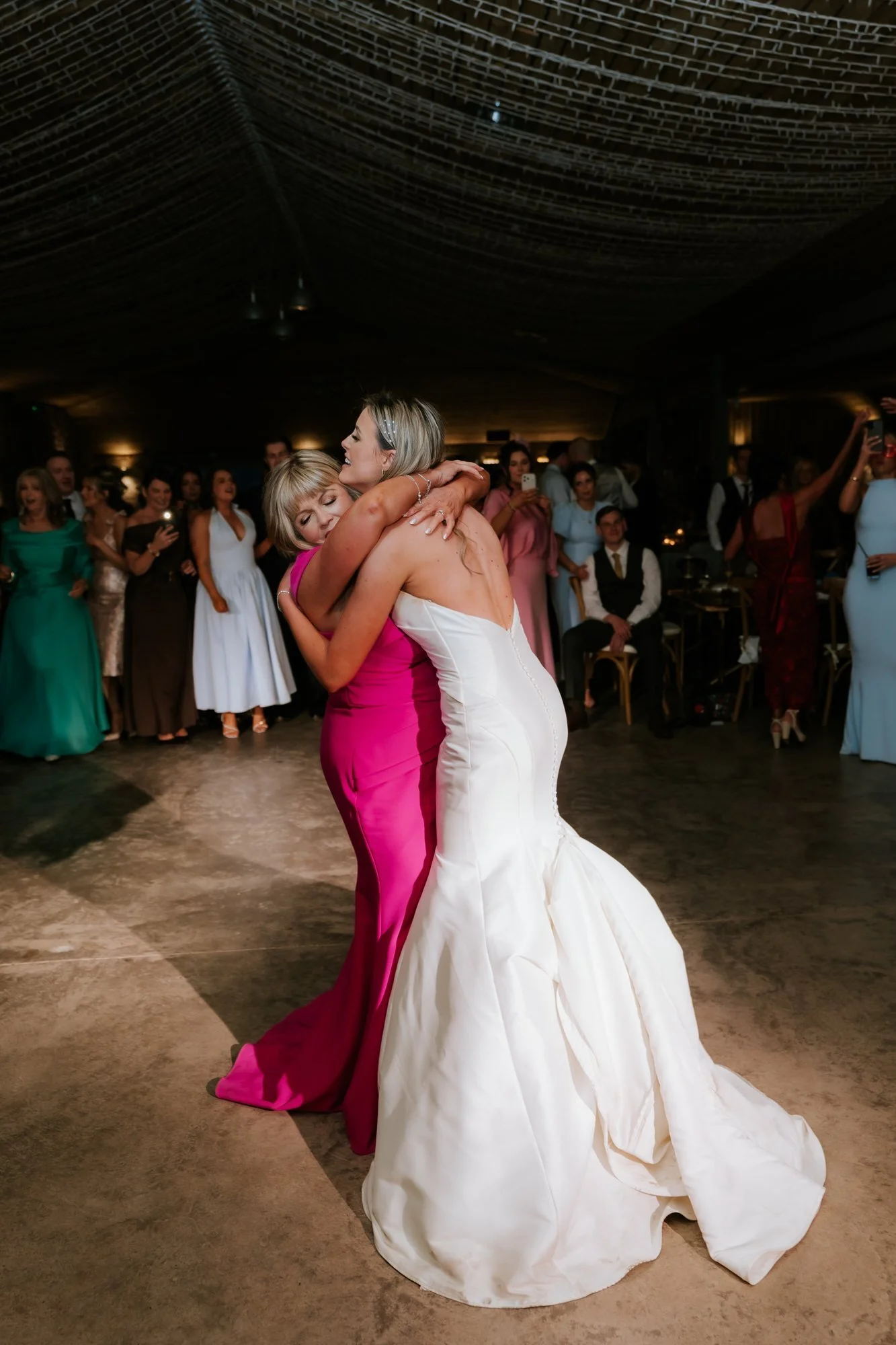 Natalie embracing a woman in pink on the dance floor