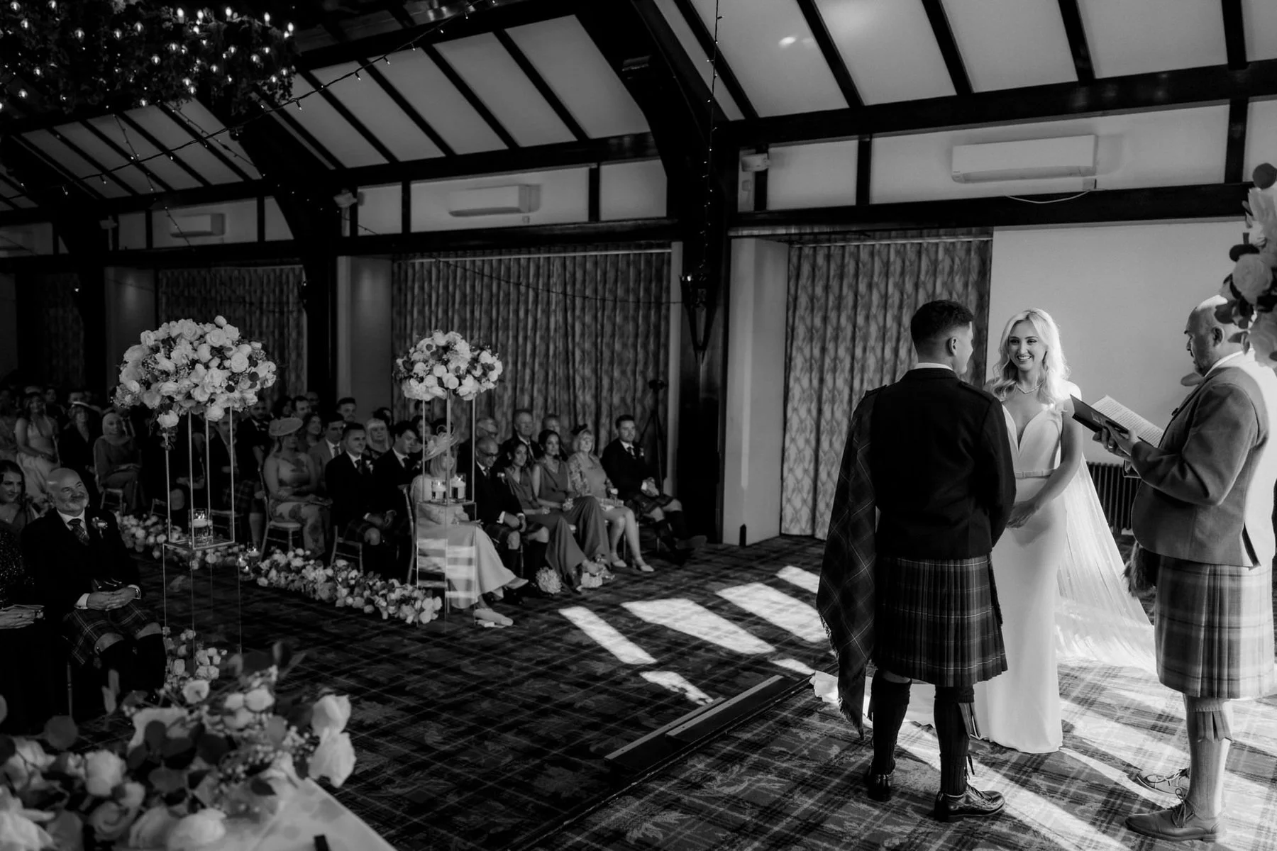 The wedding ceremony seen from behind Lauren and Zen, with their guests seated in the ballroom.