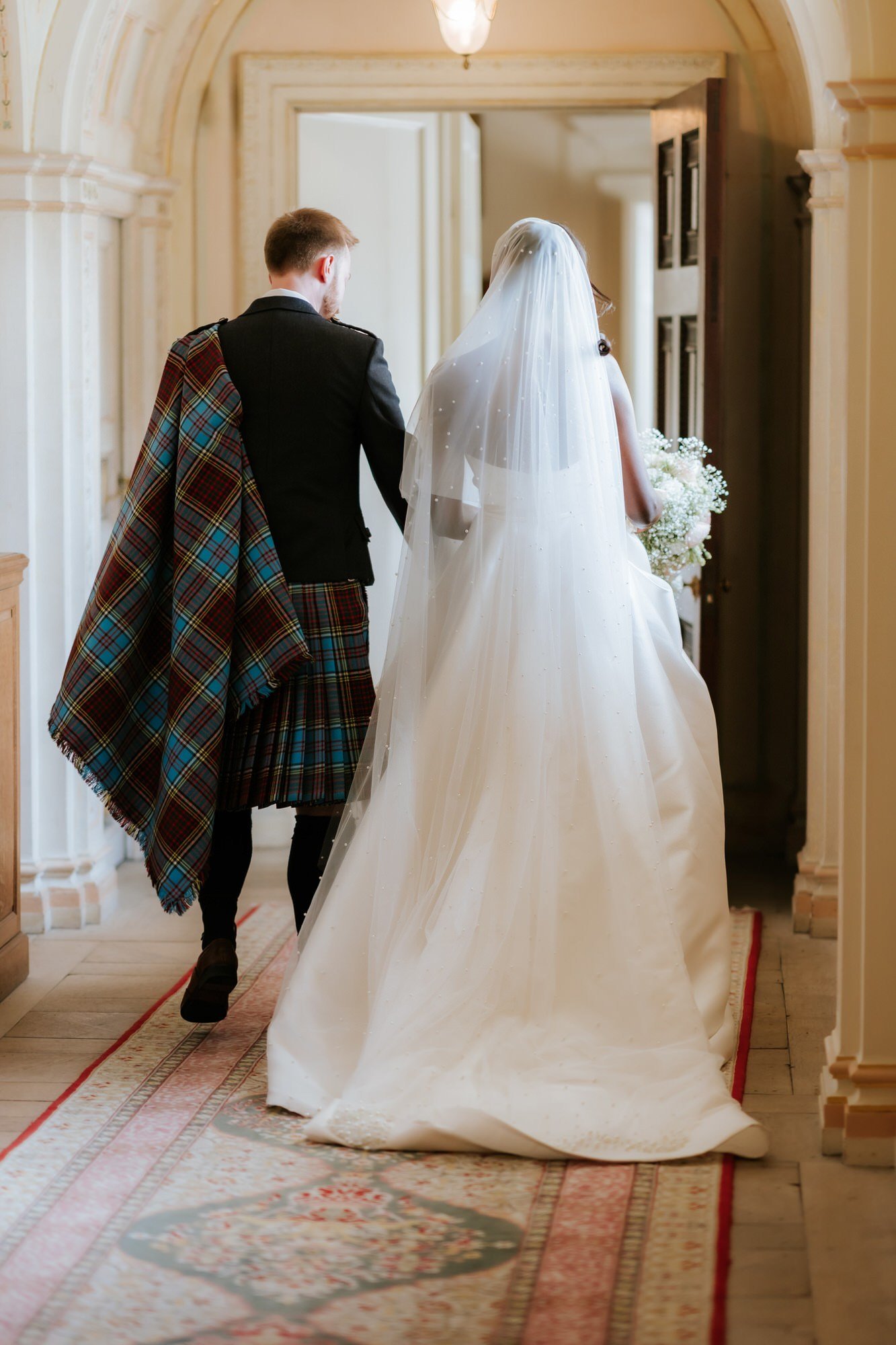 Kuda and Jamie walking through Dumfries House after the ceremony.