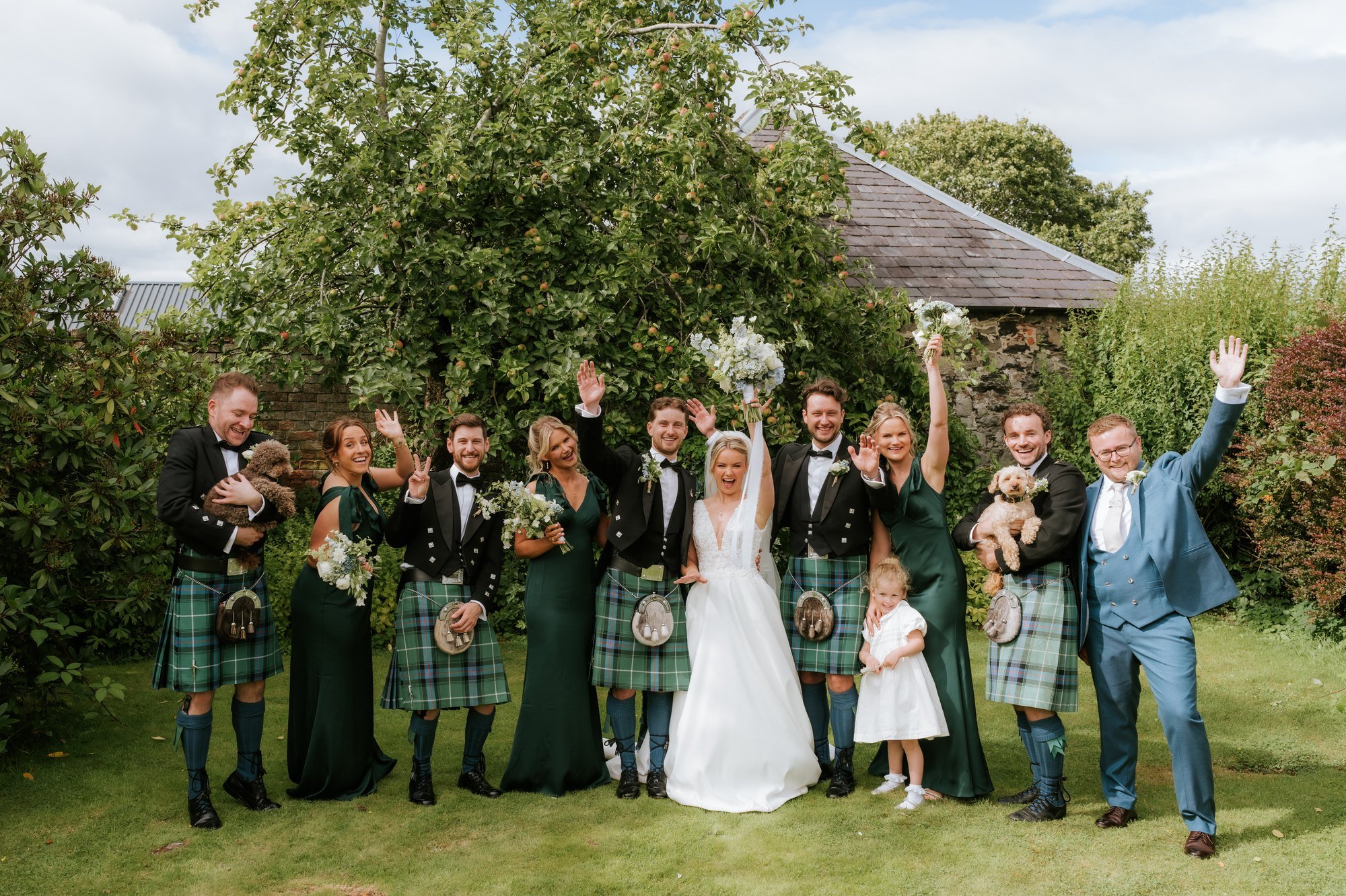 Lilian and Luke celebrating with their wedding party in the gardens.