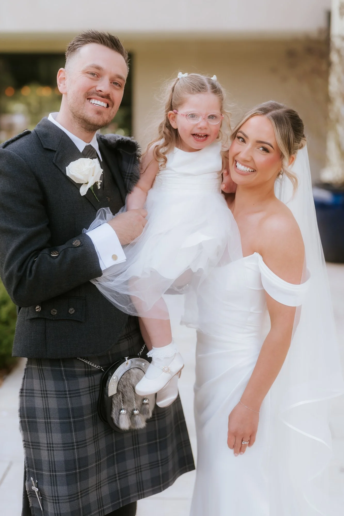 Elle and Adam smiling together with their daughter