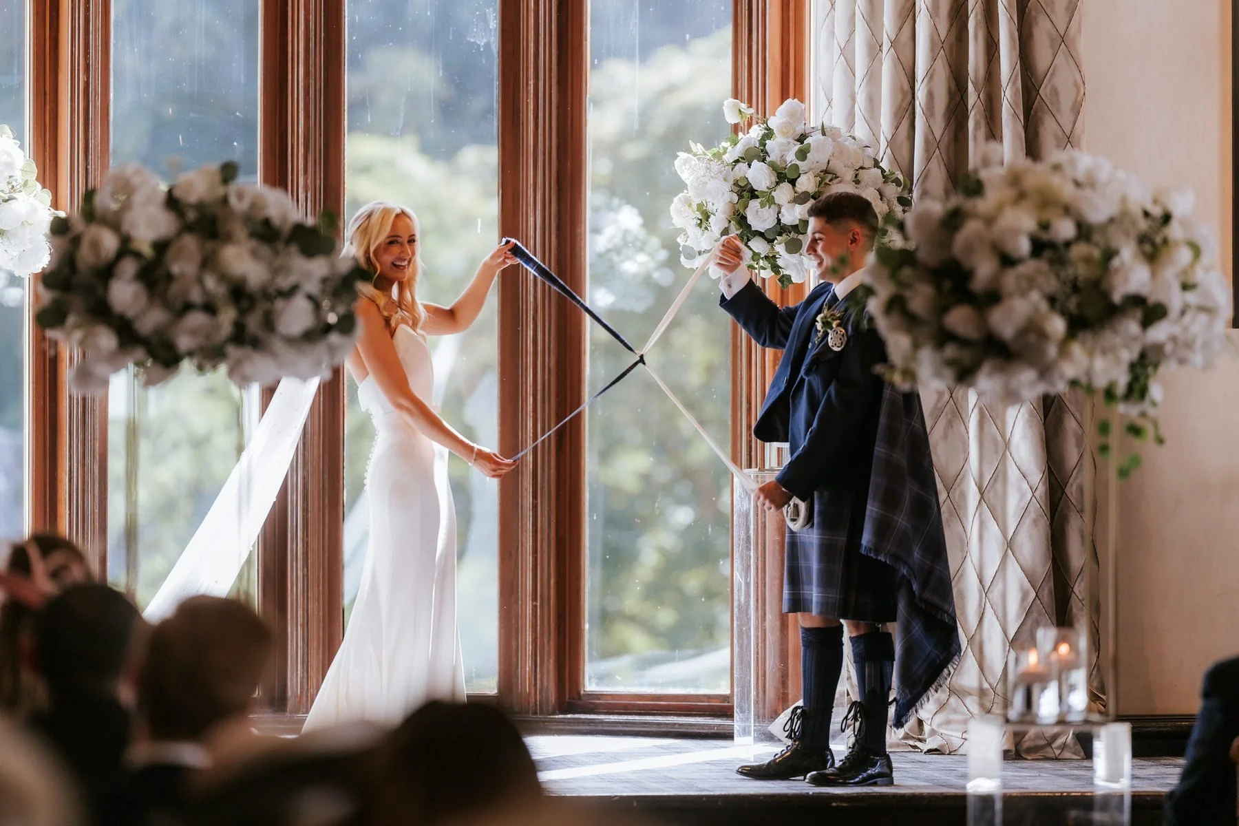 Lauren and Zen raising their joined hands during their ceremony with Craig Aikman.