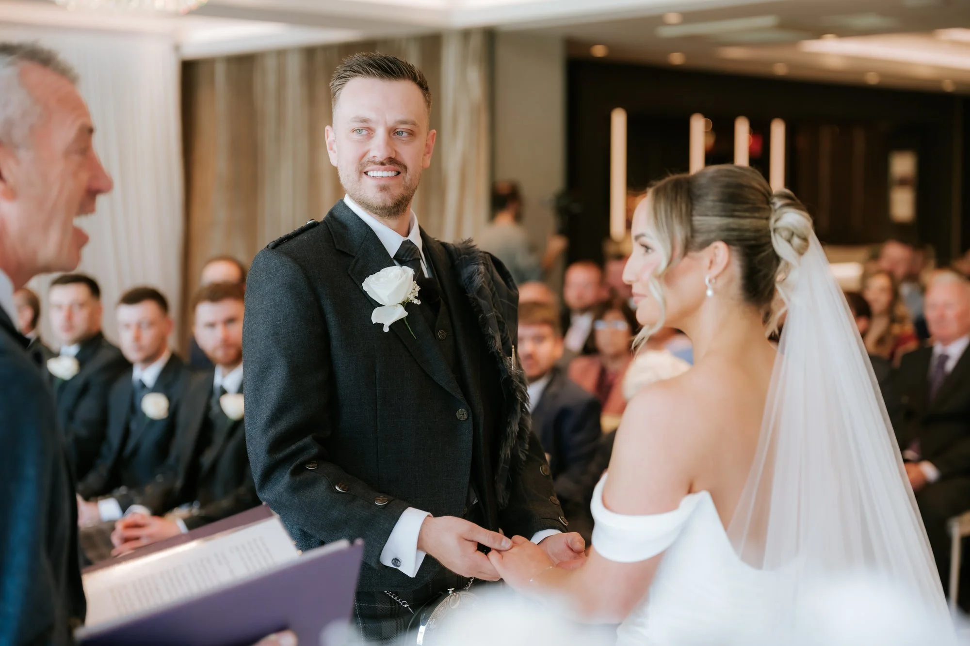 Elle and Adam holding hands during their ceremony at Dalmeny Park