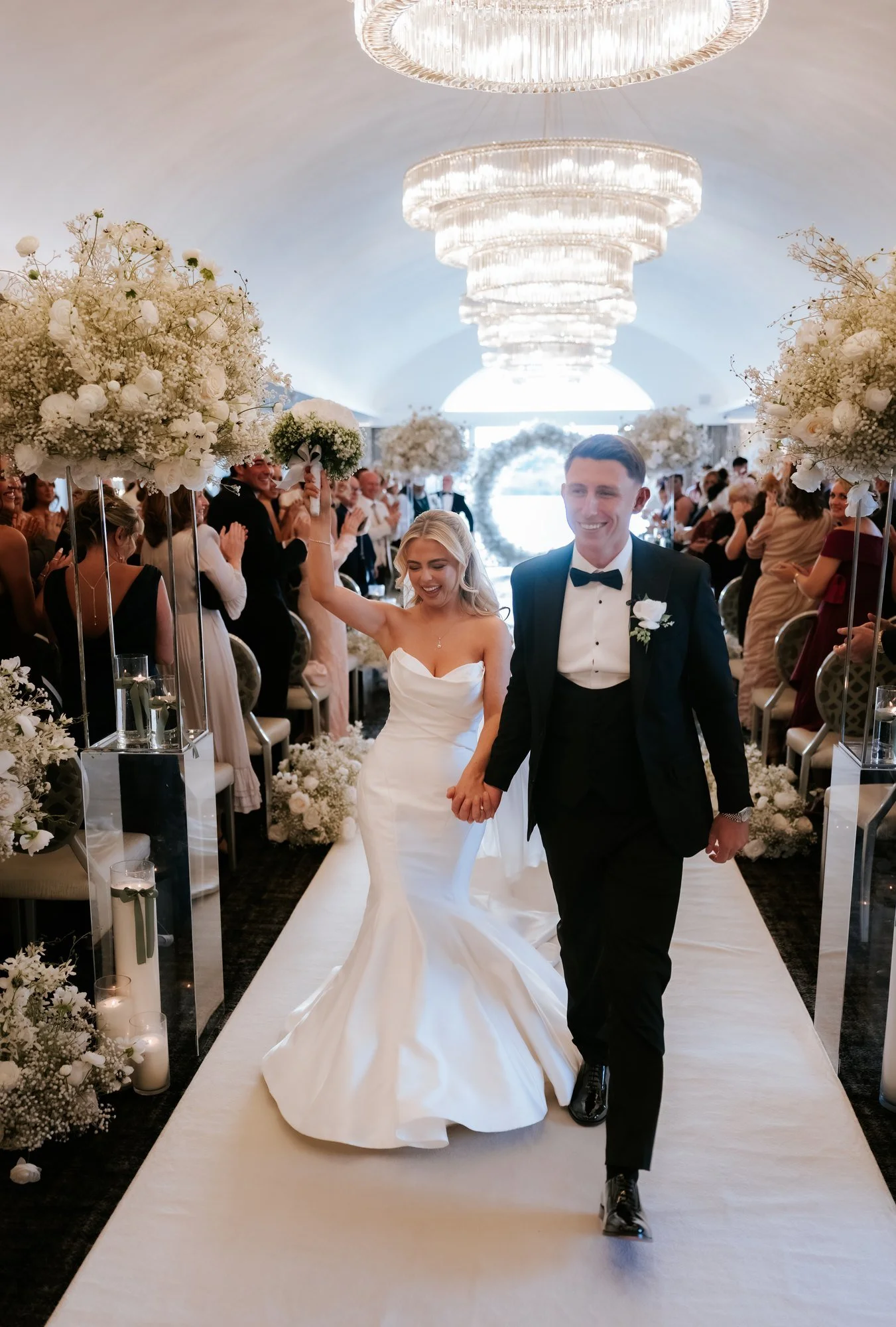 Aiden and Taylor celebrating as they walk back up the aisle.