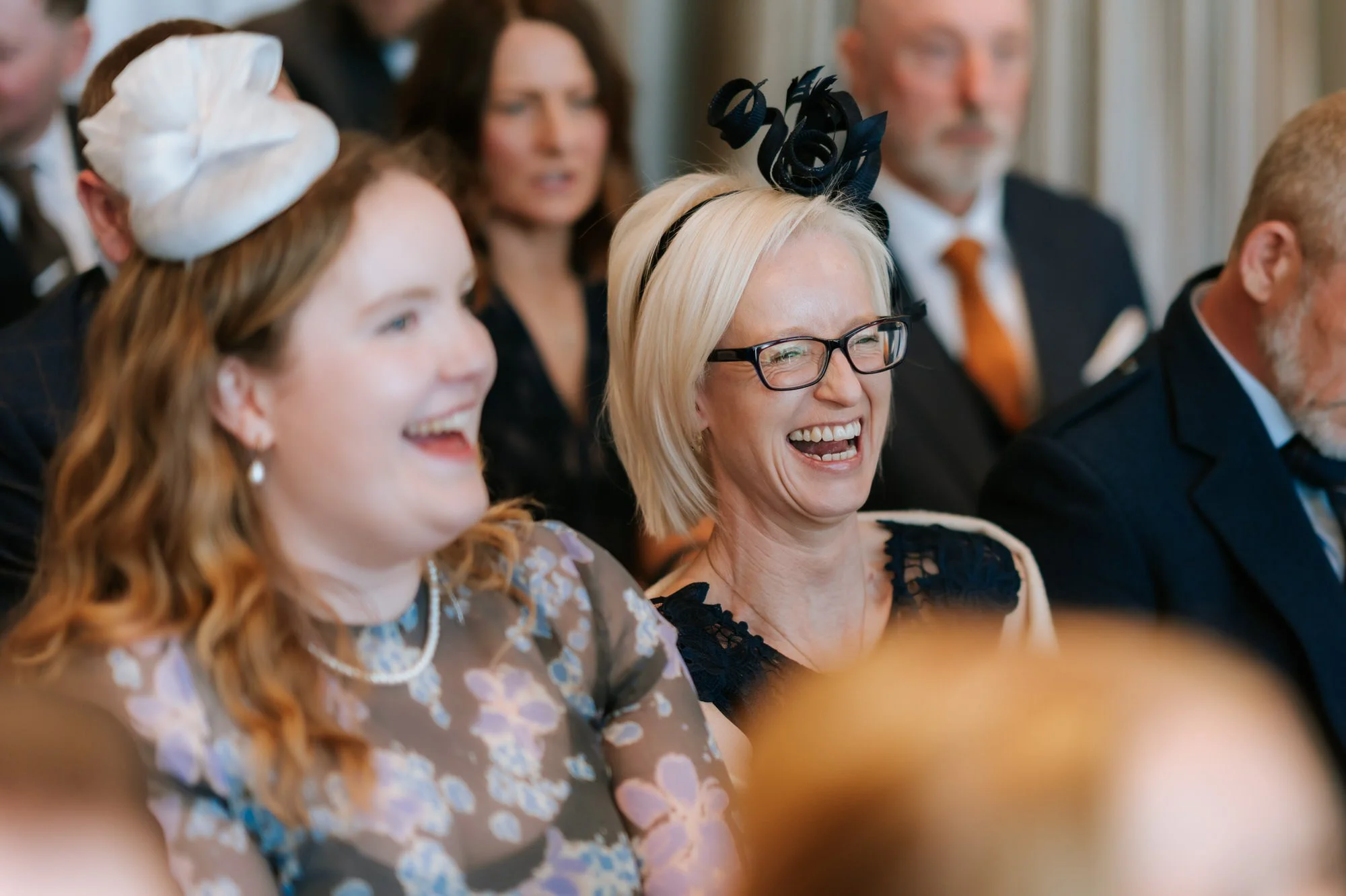 Two guests smiling together during the wedding ceremony