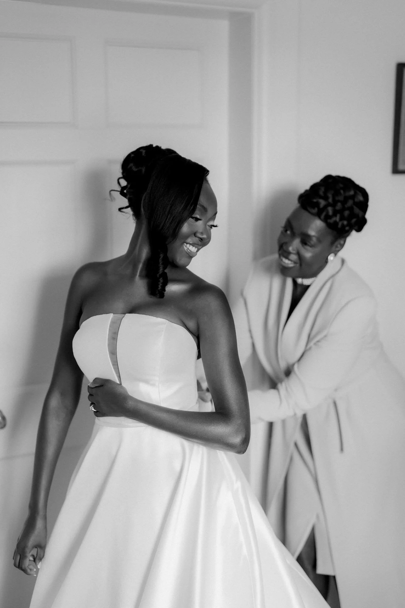 Kuda laughing with her mum while getting ready, in black and white.