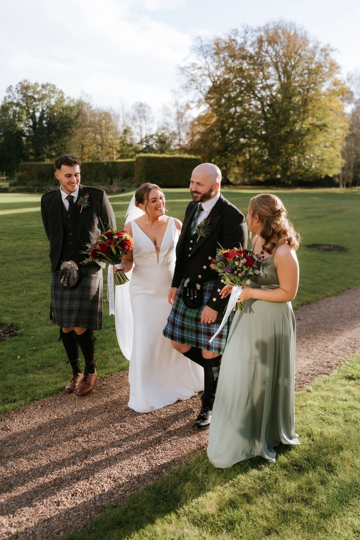Kendall and Ewen sharing a laugh with two guests on the garden path.