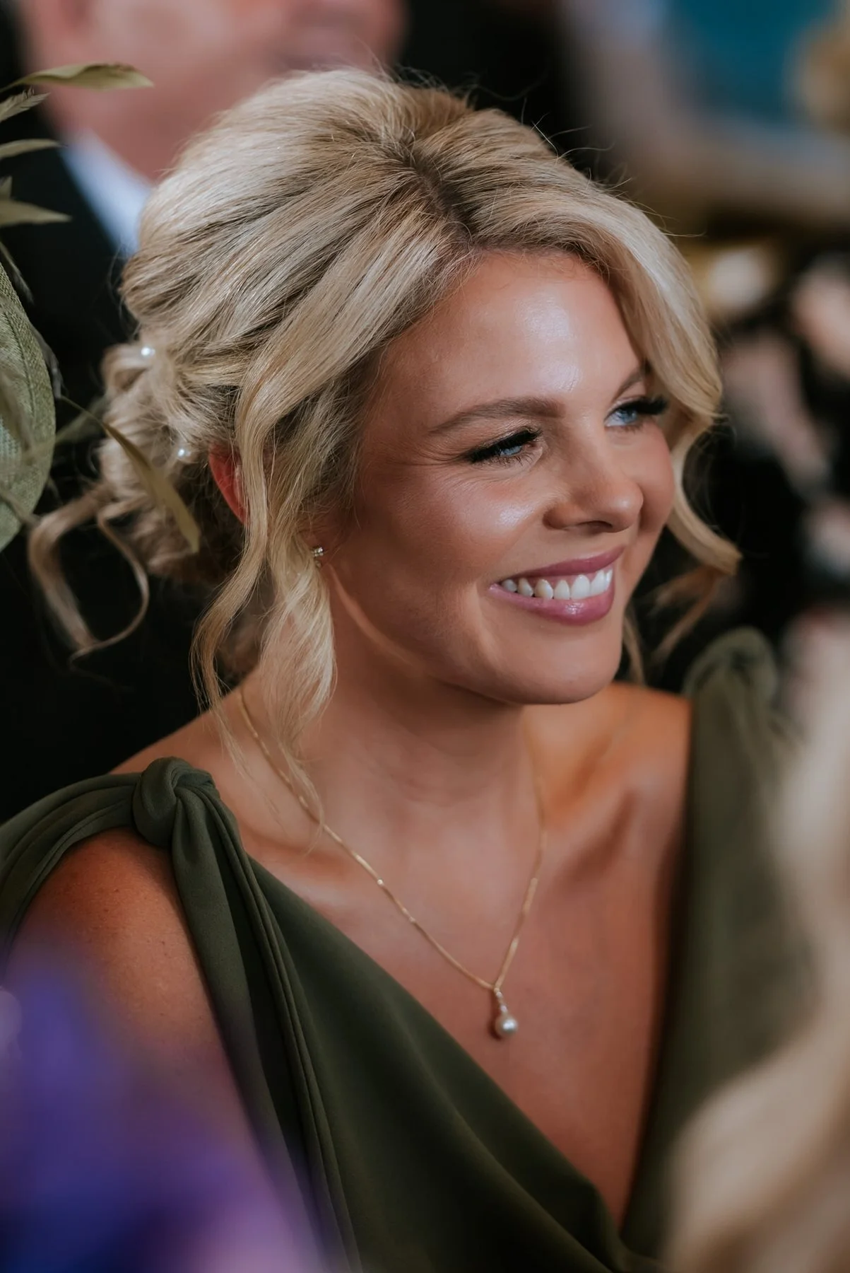 A bridesmaid smiling as she watches Lauren and Zen exchange their vows.
