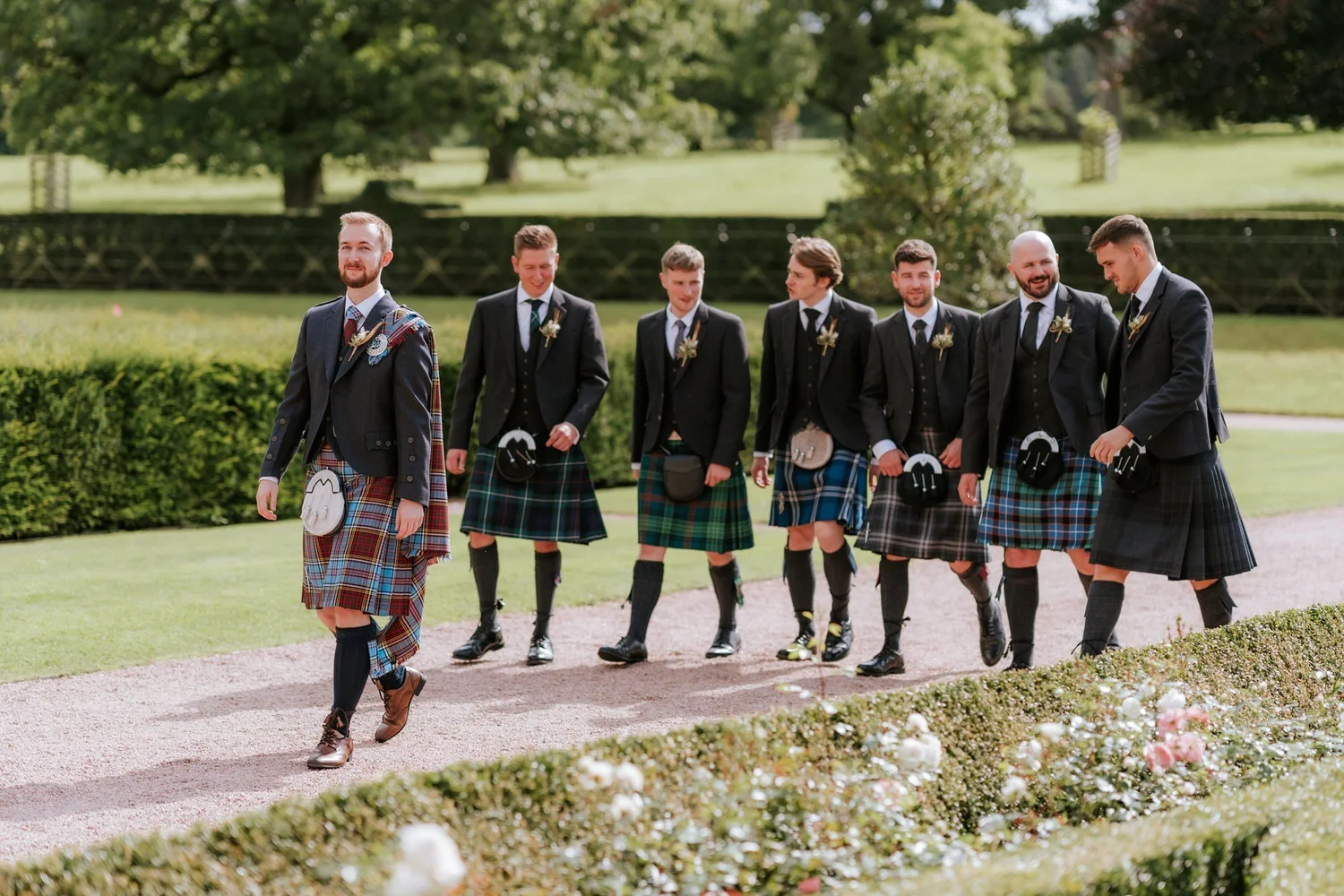 Jamie and his groomsmen walking together through the gardens.
