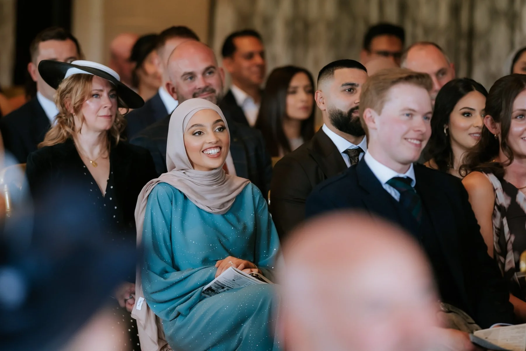 Guests smiling together during the wedding ceremony.