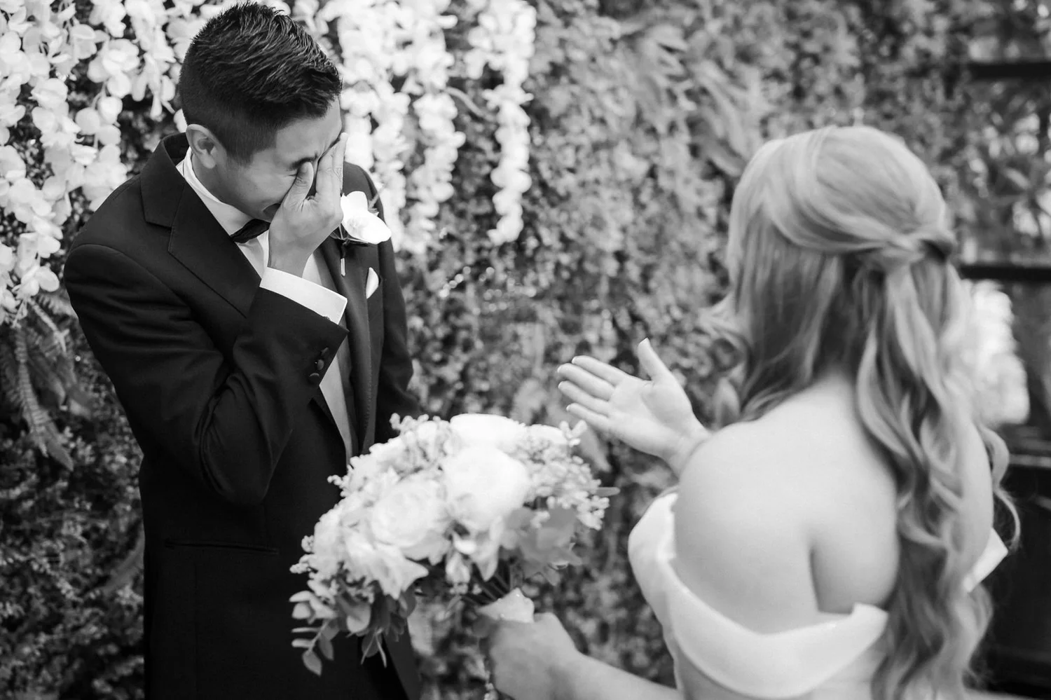 Black-and-white photograph of Carl wiping away a tear during his first look with Allie.