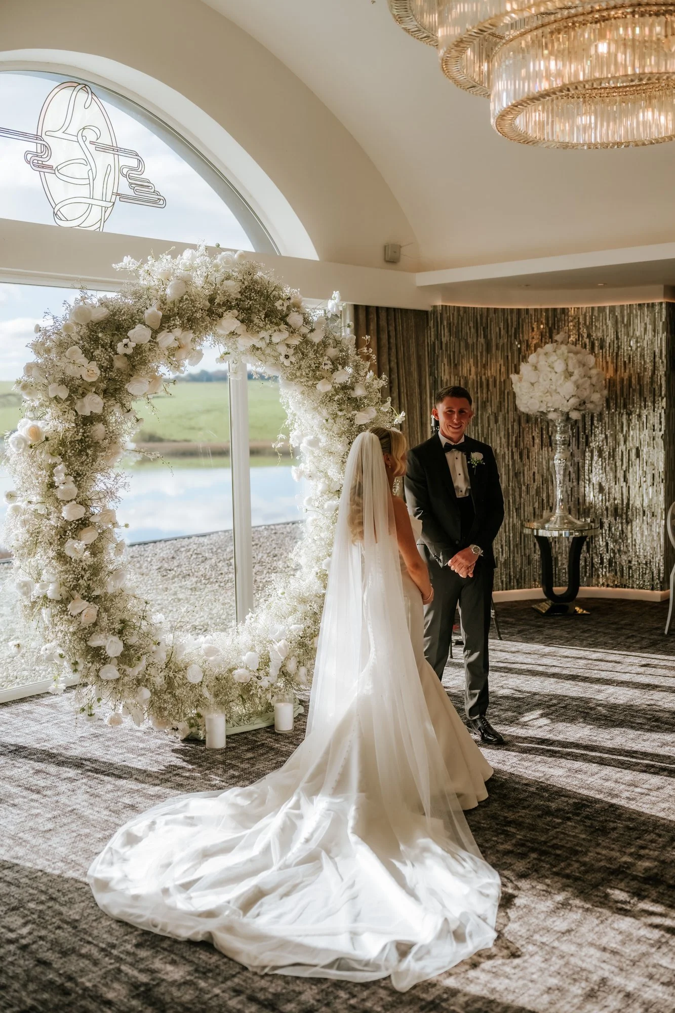 Taylor and Aiden beneath the circular floral arch during their ceremony.
