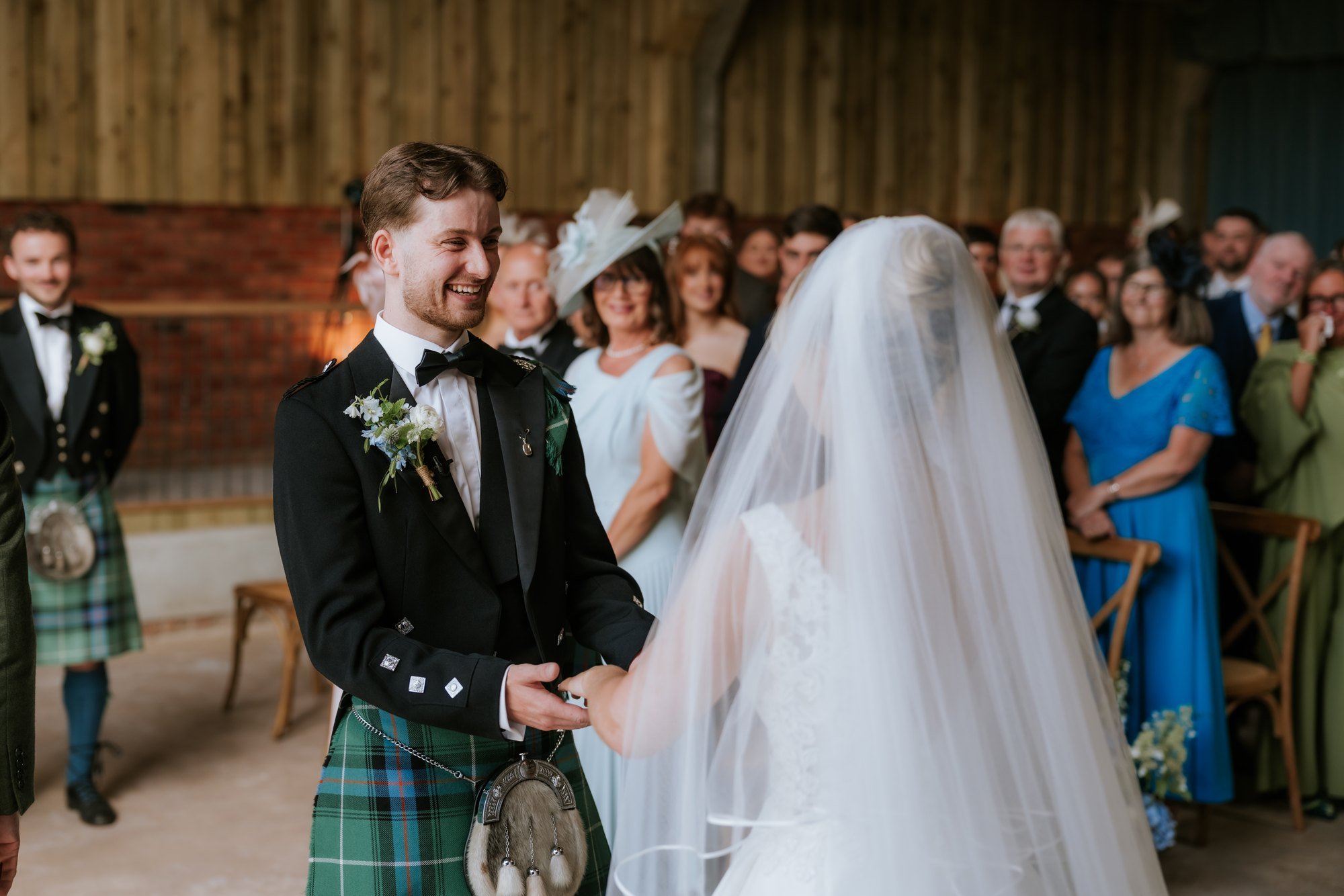 Luke smiling as Lilian joins him at the front of the ceremony room.