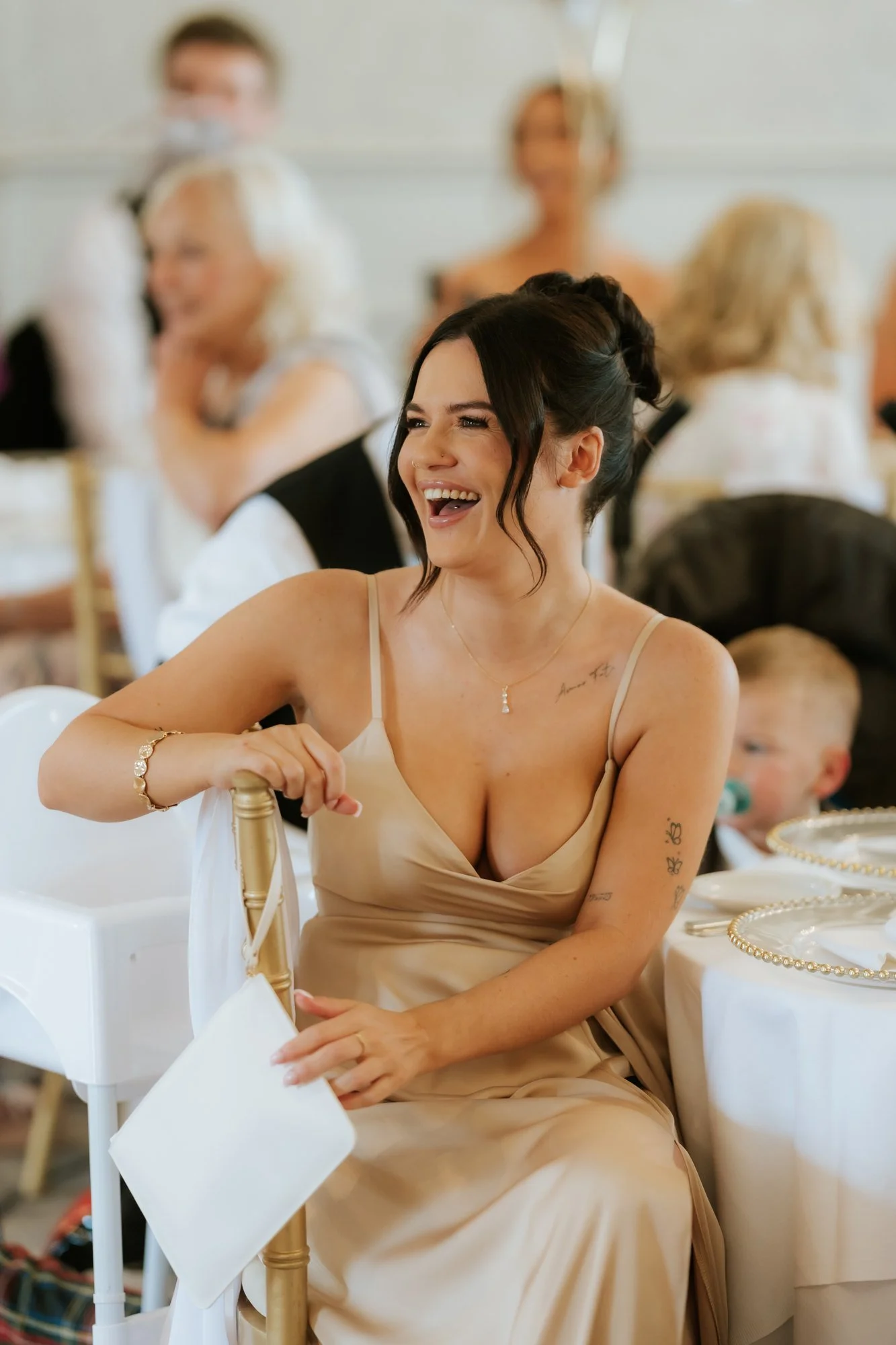A bridesmaid laughing with a white napkin in her hand at Glenbervie House.
