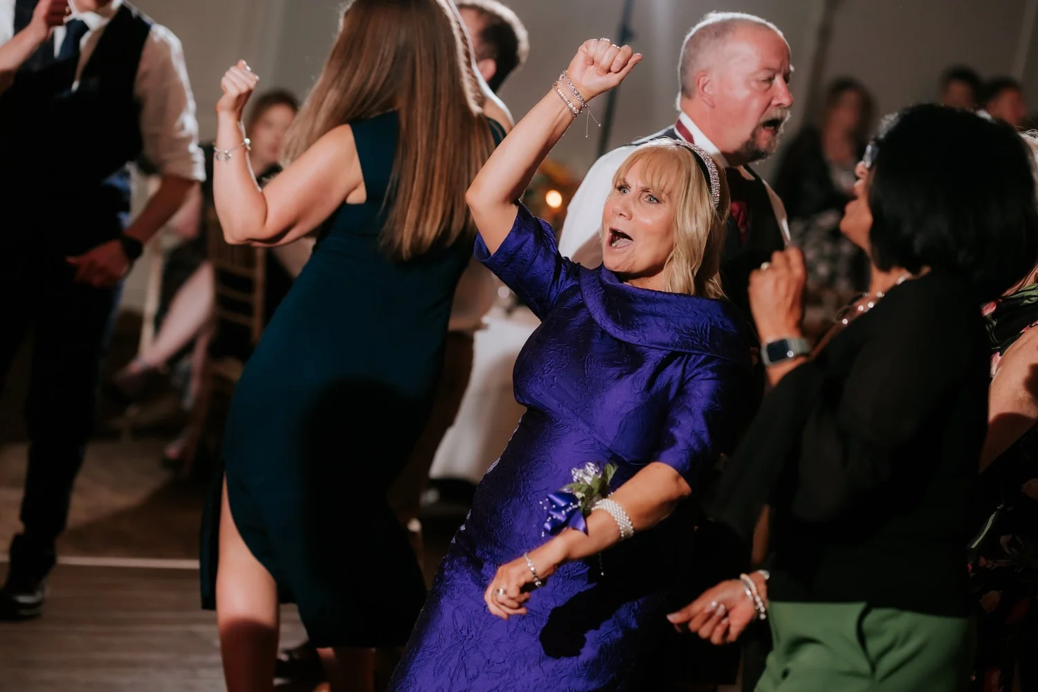 Guests dancing with their arms in the air during the evening celebrations.