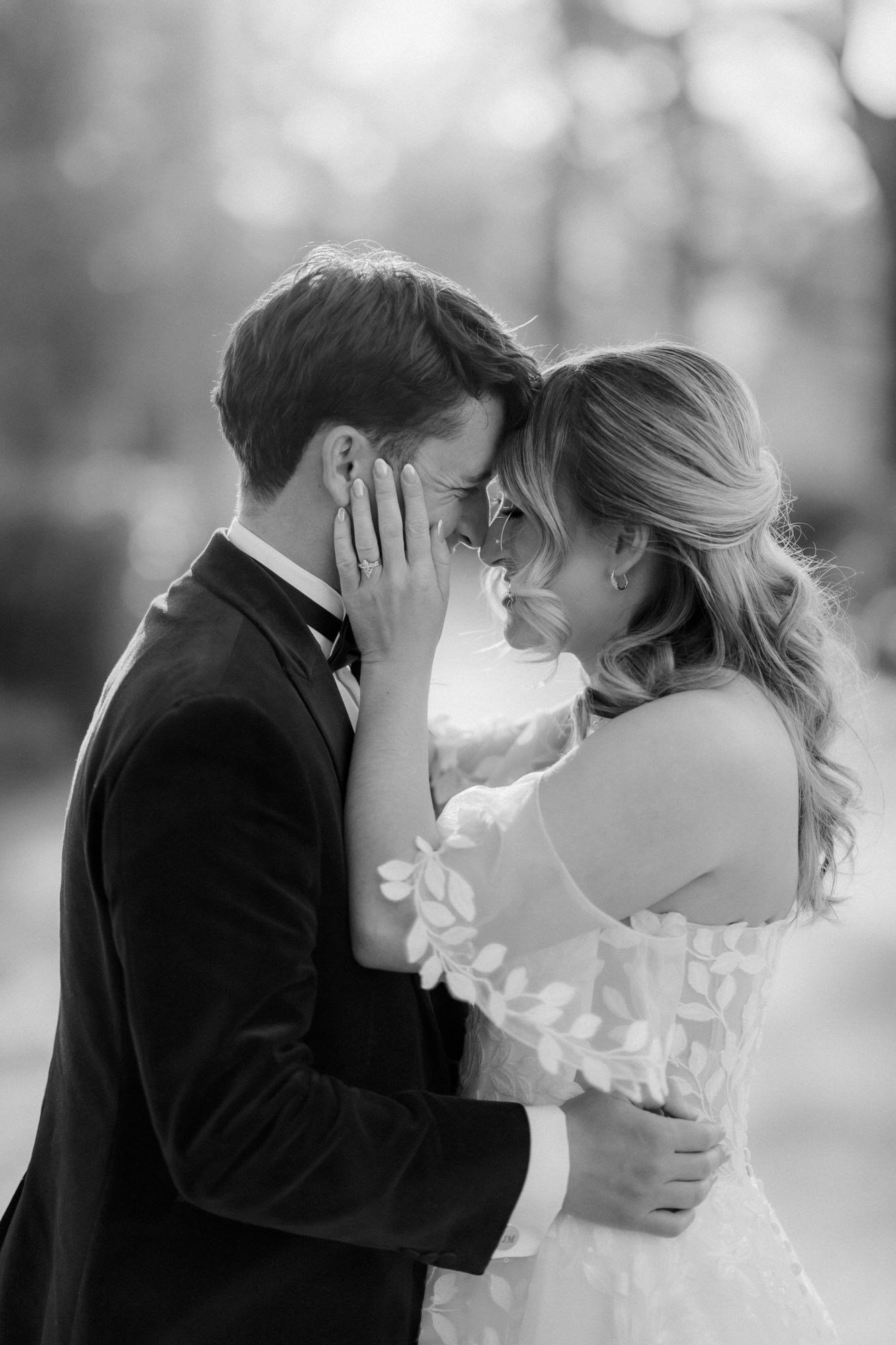 A close black and white portrait of Ciara and Jonathon embracing.