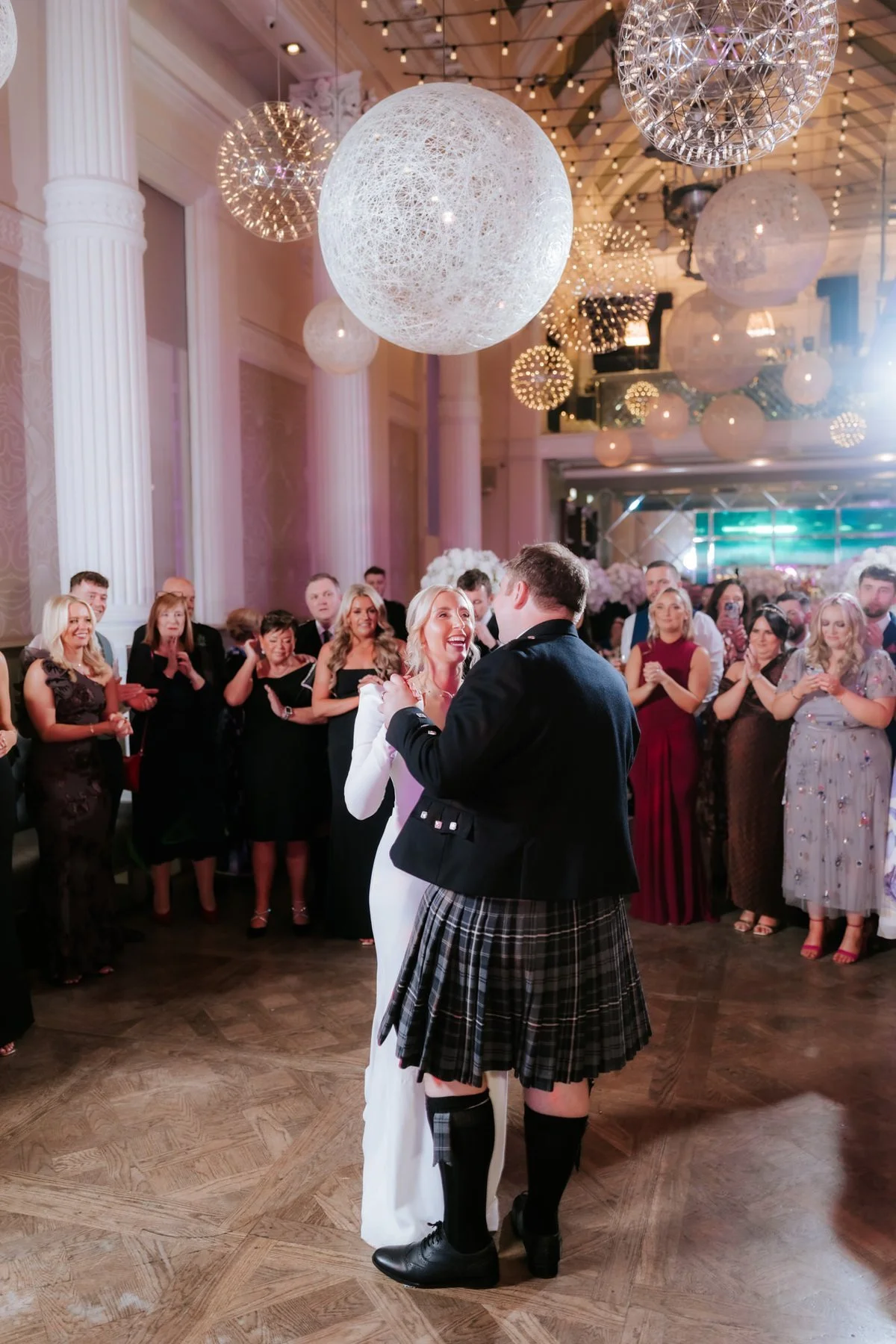 Jen and Jordan dancing together beneath the Corinthian’s hanging globe lights.