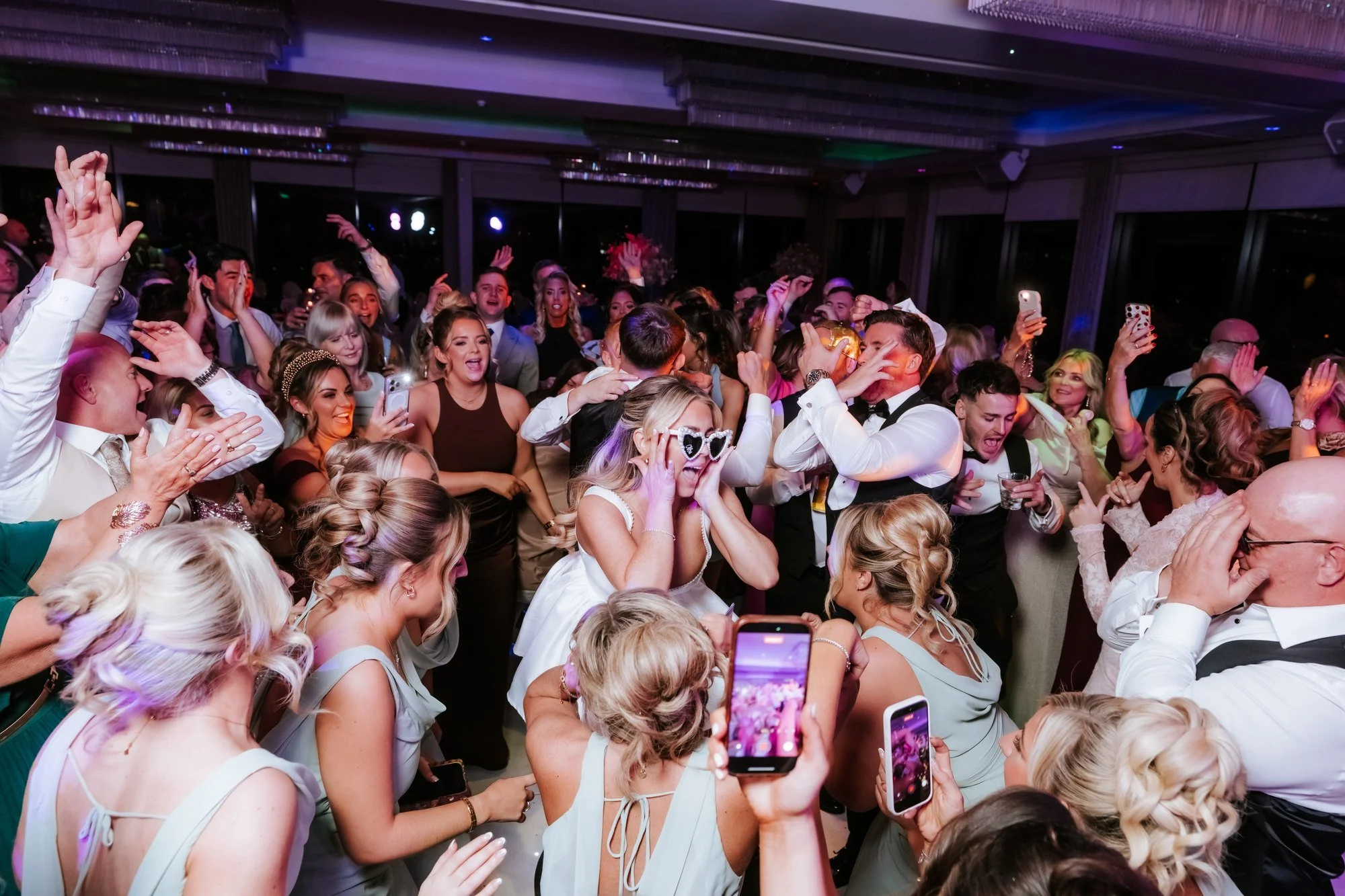 A packed dance floor celebrating with the newlyweds.