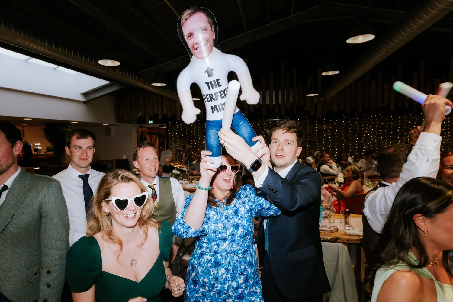 Guests cheering with an inflatable man during the wedding celebrations.
