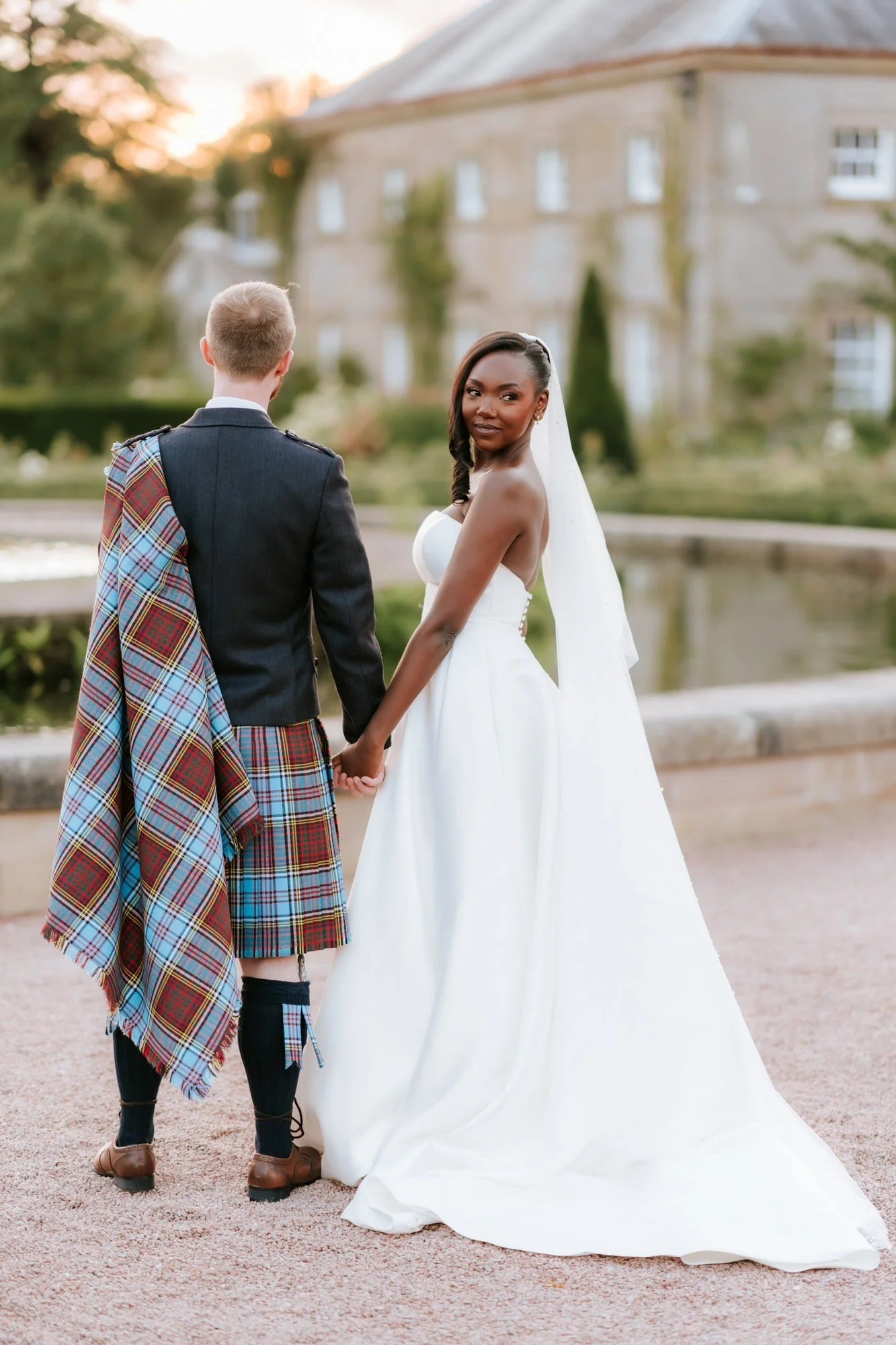 Kuda looking back while holding Jamie’s hand by the fountain.