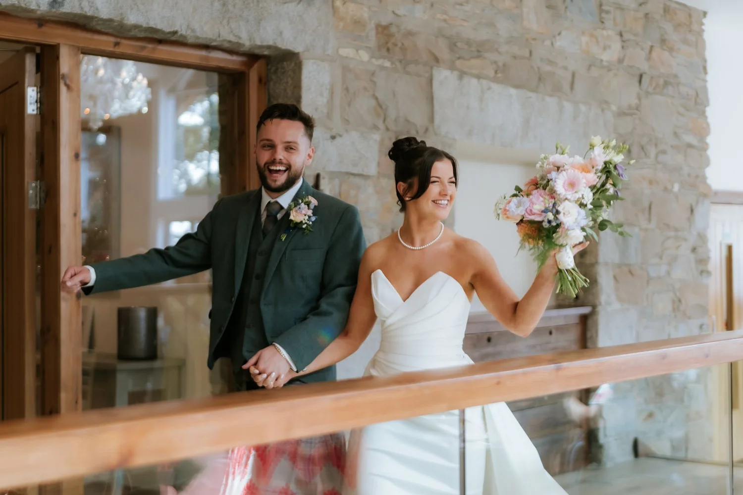 Lois and Dougie entering their wedding reception at GG’s Yard, smiling and holding hands.