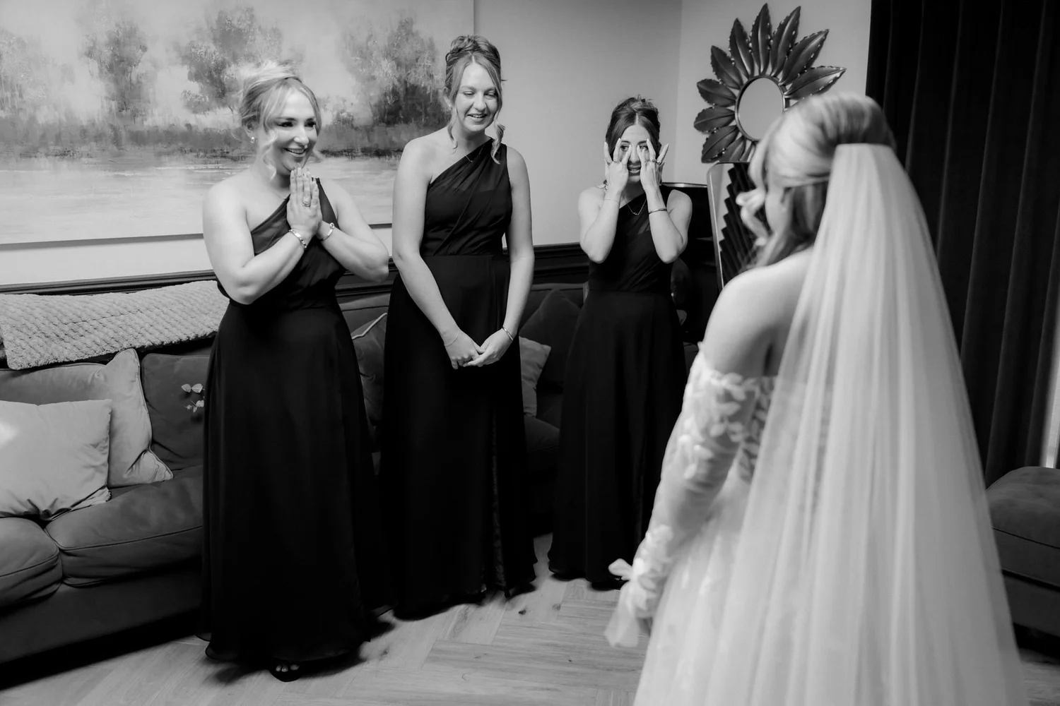The bridesmaids reacting as they see Ciara in her wedding dress.