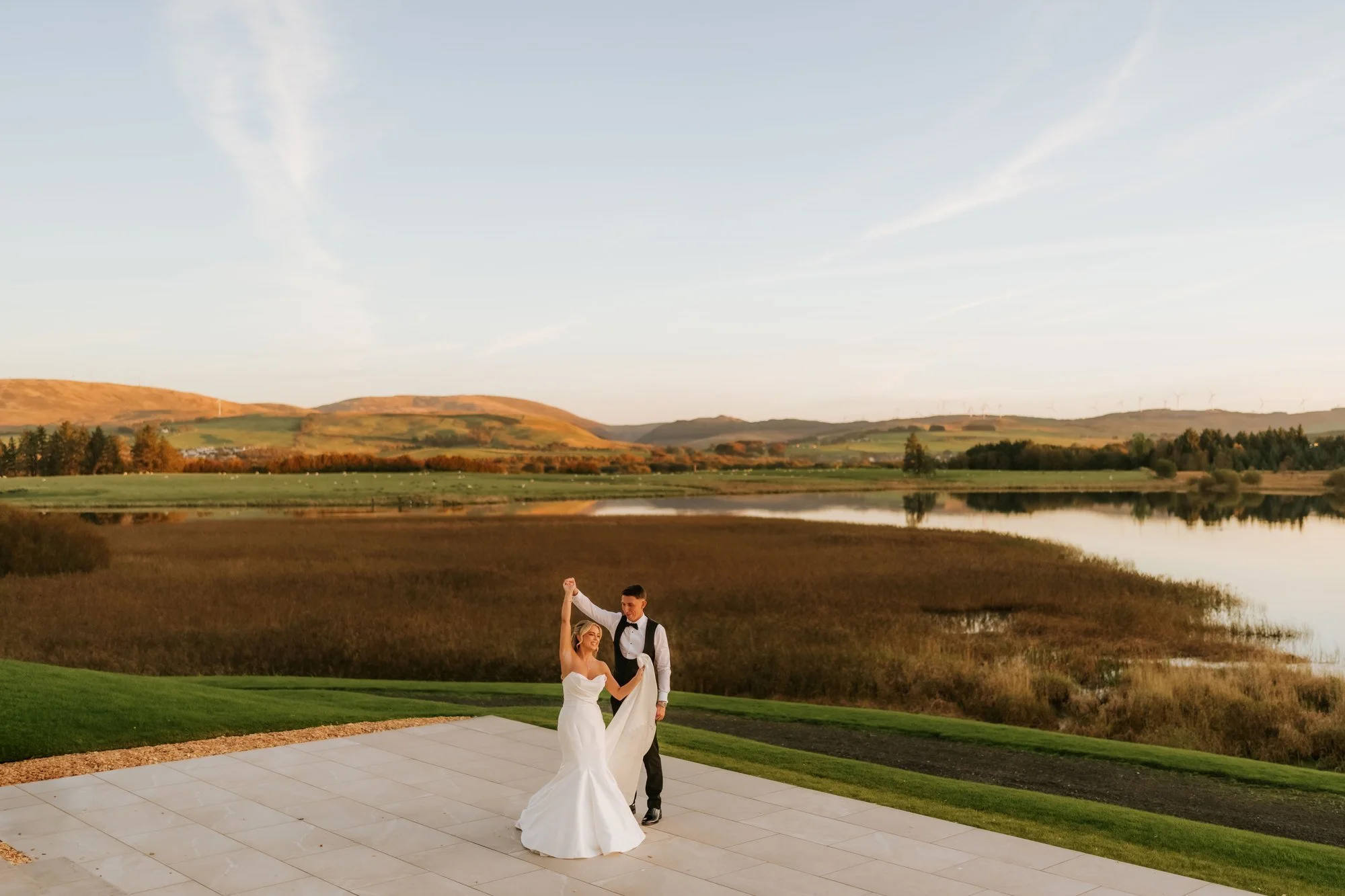 Aiden twirling Taylor on the terrace as evening light falls over the loch.
