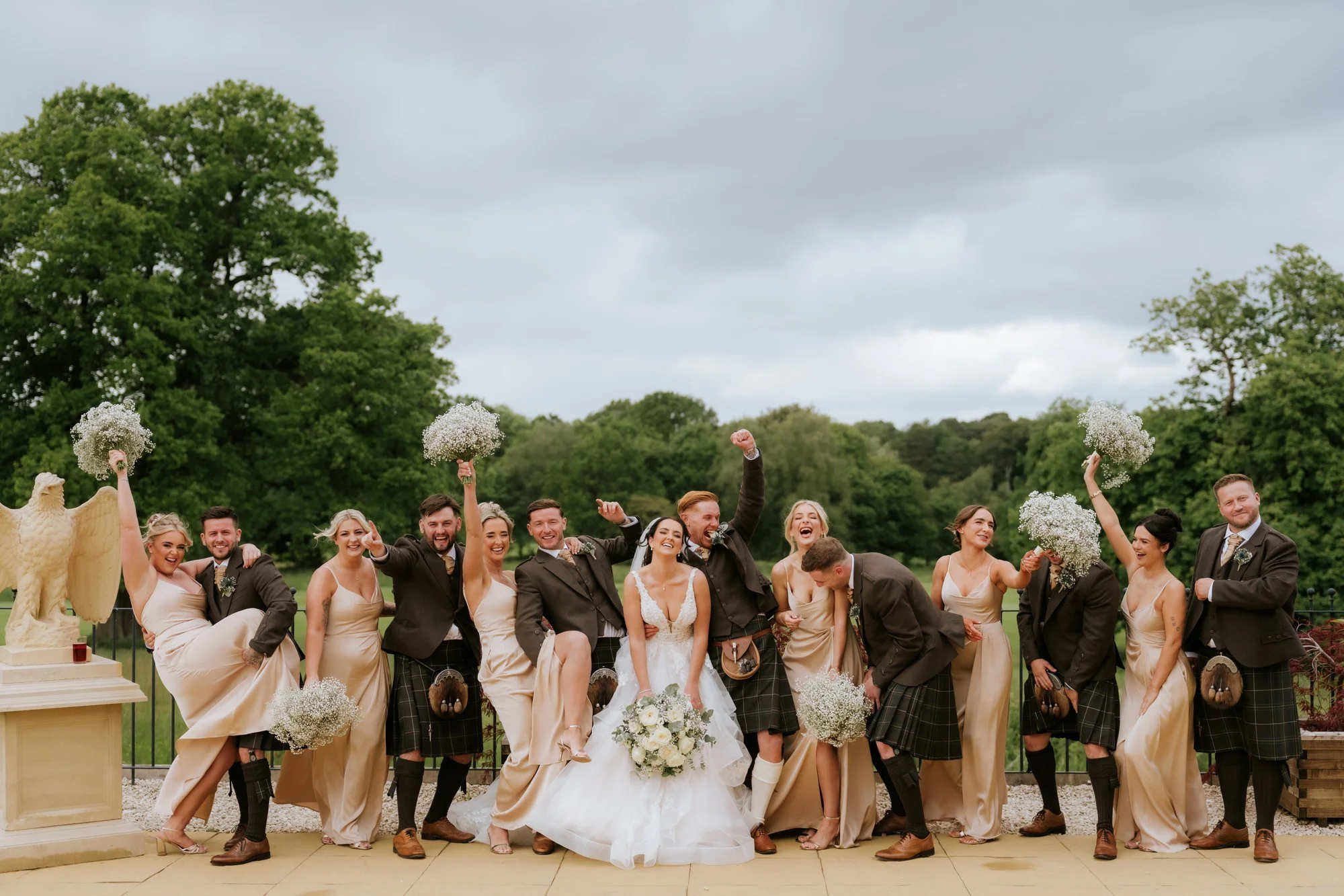 Kaitlyn and Scott laughing with their wedding party outside Glenbervie House.