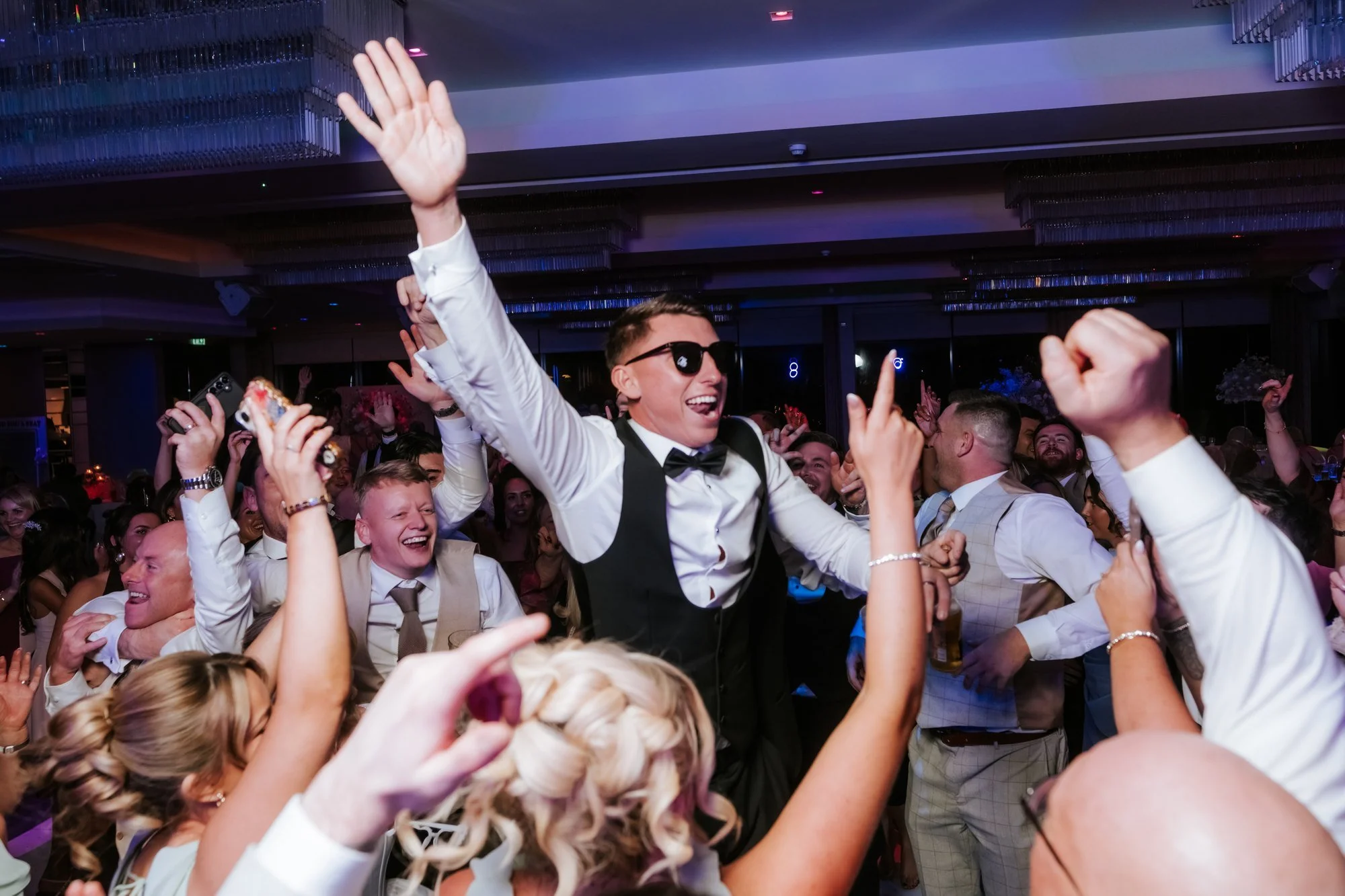 Aiden celebrating with friends on the wedding dance floor.