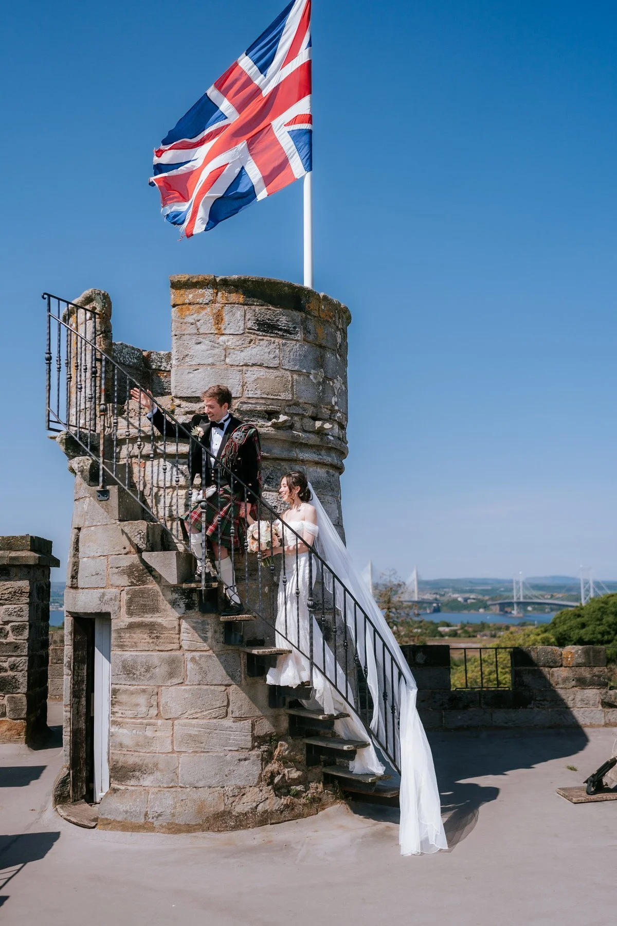 Kenneth and Kim on the steps beside the rooftop turret and Union flag at Dundas Castle.