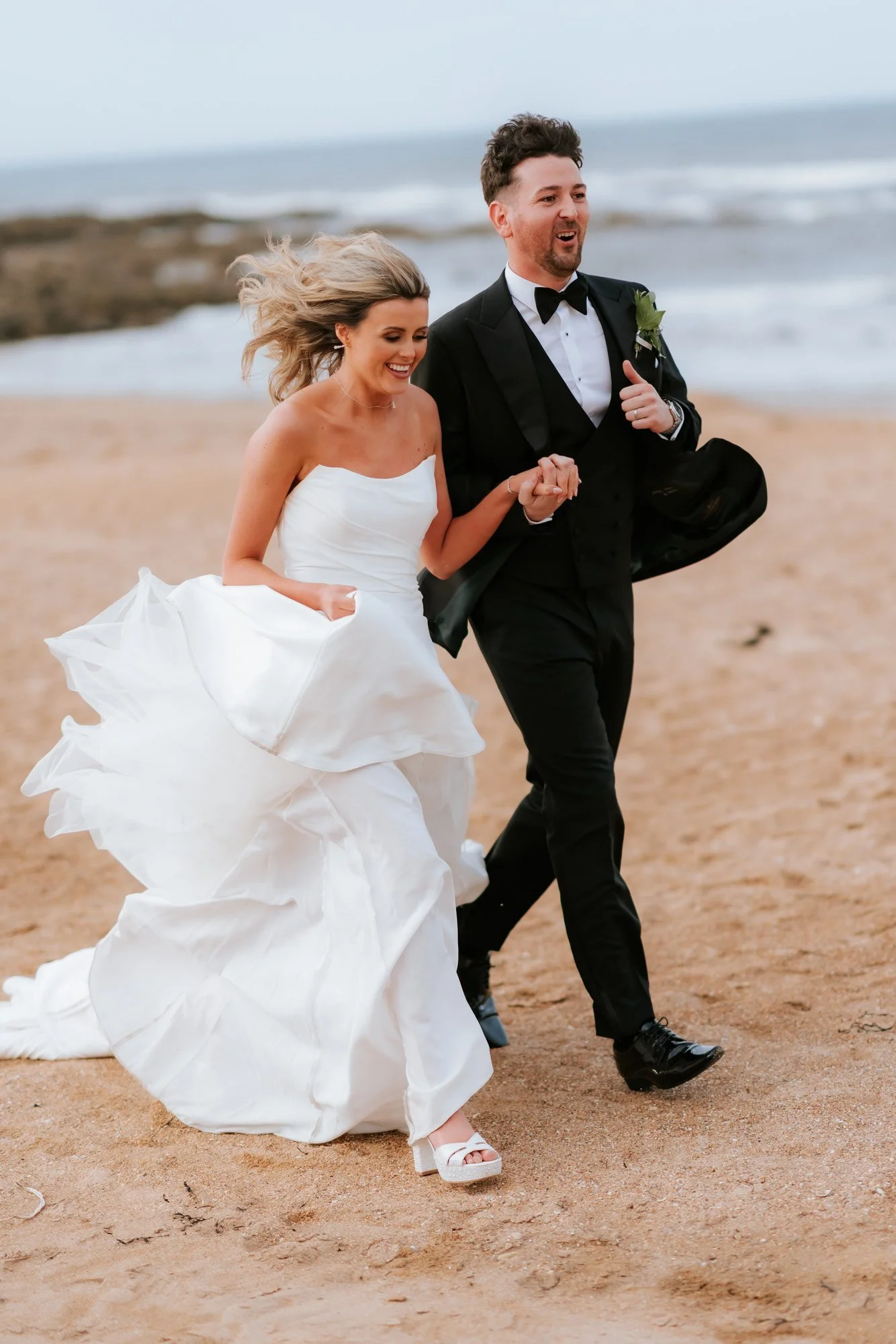 Natalie and Jamie running together along Kingsbarns beach