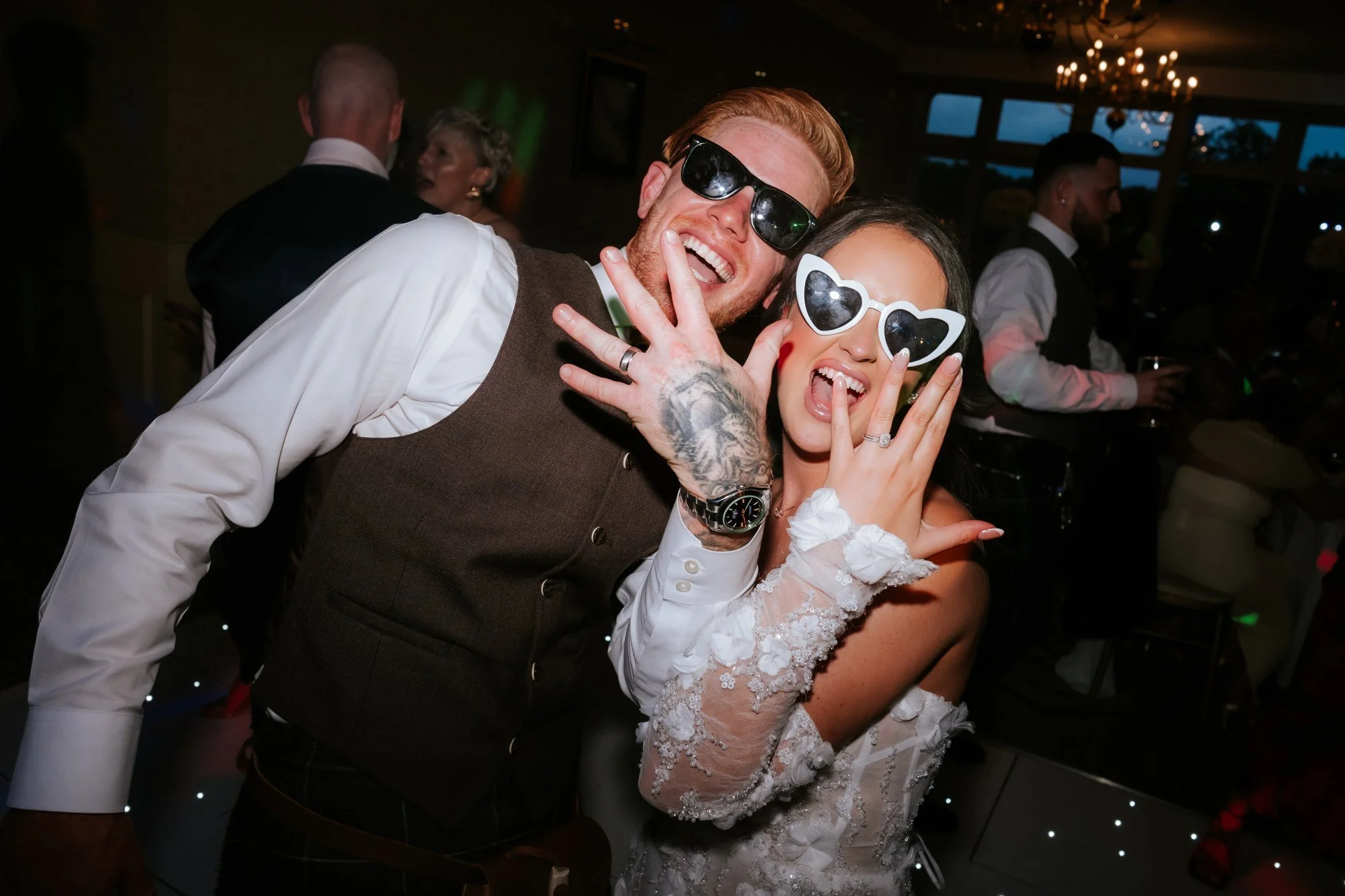Kaitlyn and Scott wearing sunglasses and showing their wedding rings at Glenbervie House.