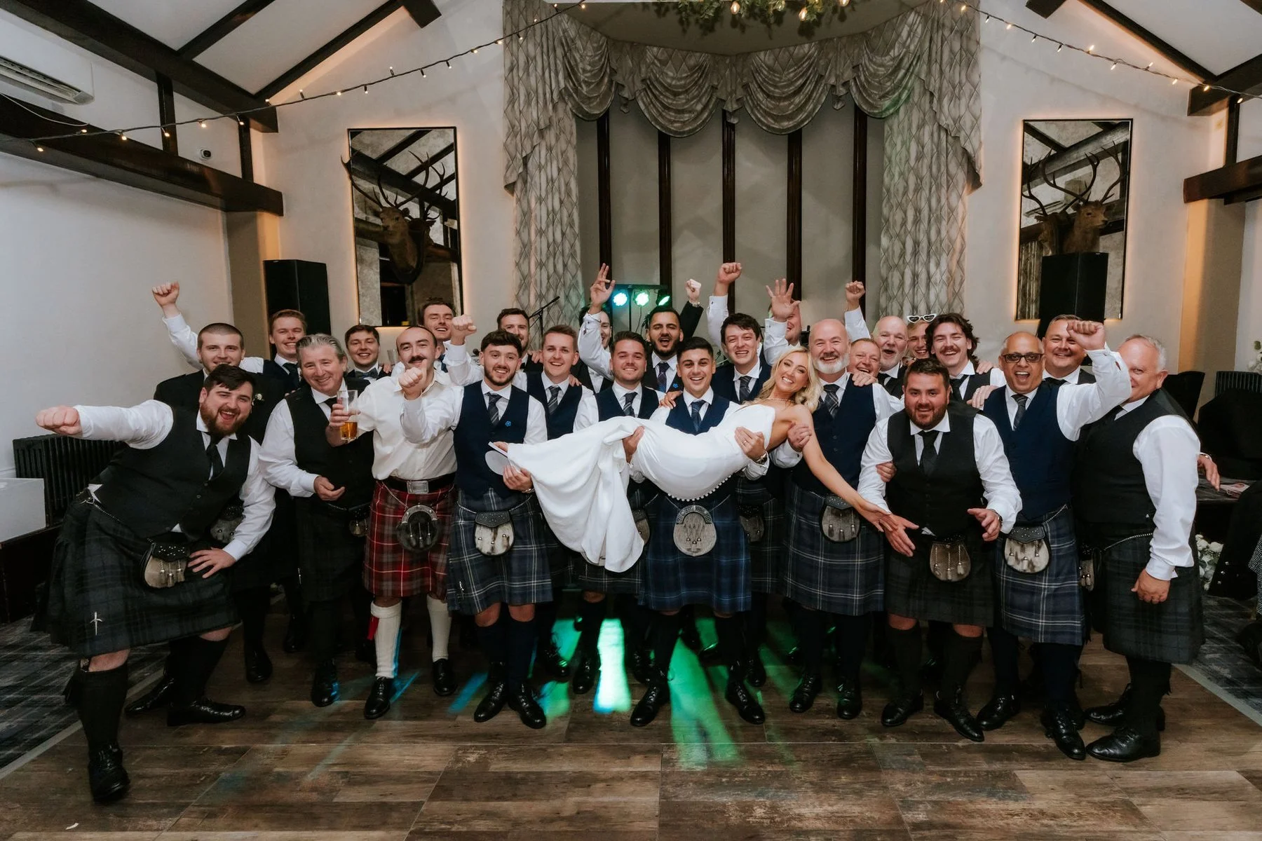 Lauren being lifted by a group of cheering wedding guests at the end of the night.