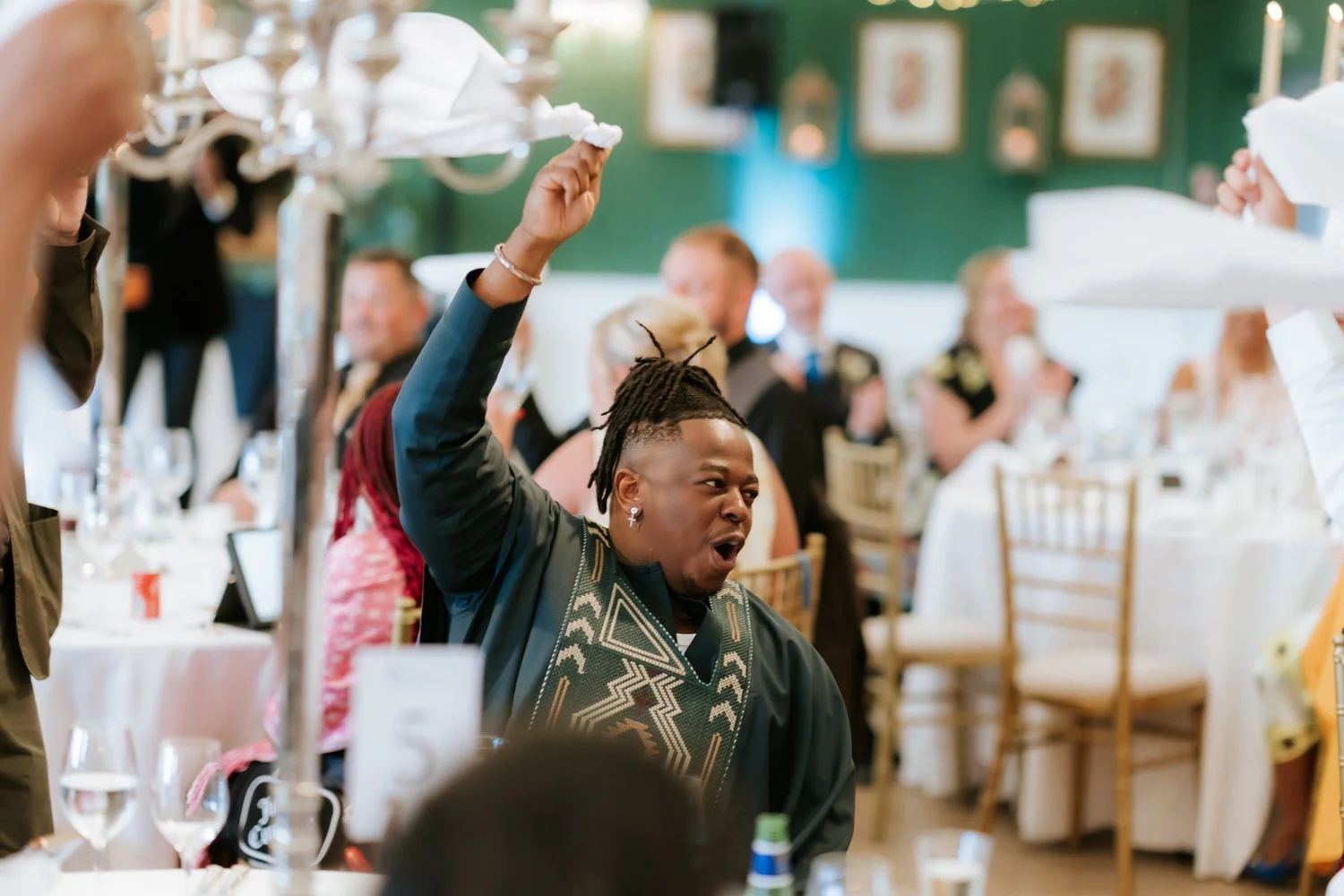 A guest celebrating with a napkin raised in the air.
