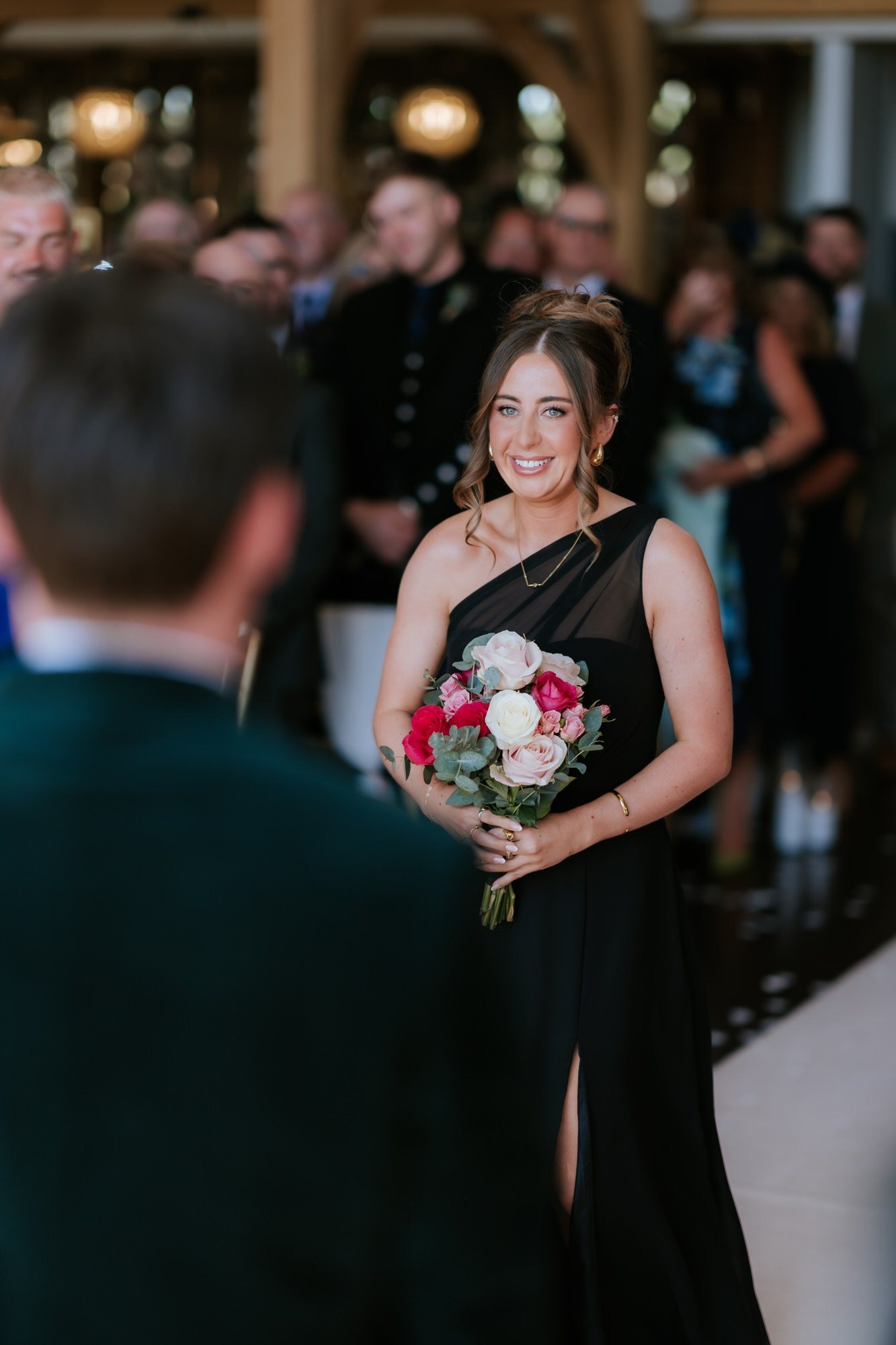 A bridesmaid approaching Jonathon at the front of the ceremony.