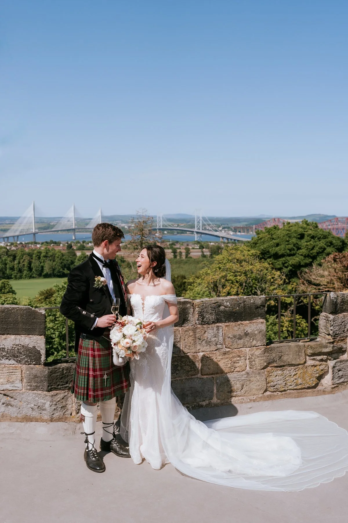 Kim and Kenneth standing together on the castle rooftop, with the bridges across the Forth in the distance.