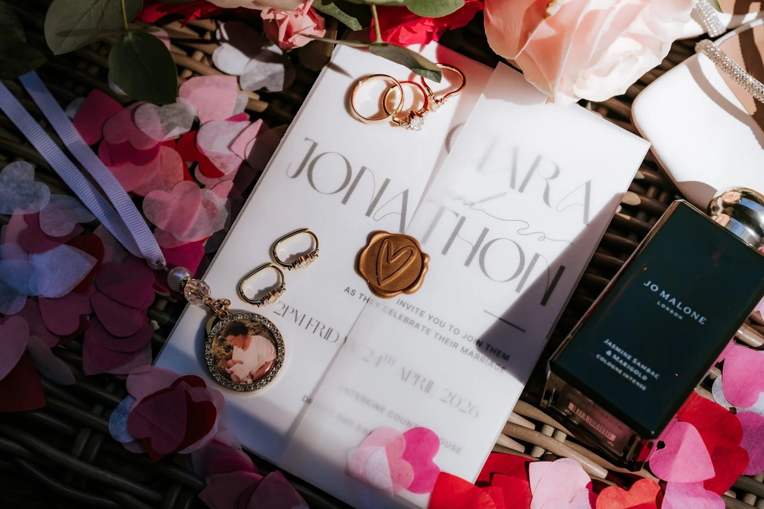 Wedding stationery, jewellery and pink heart confetti.