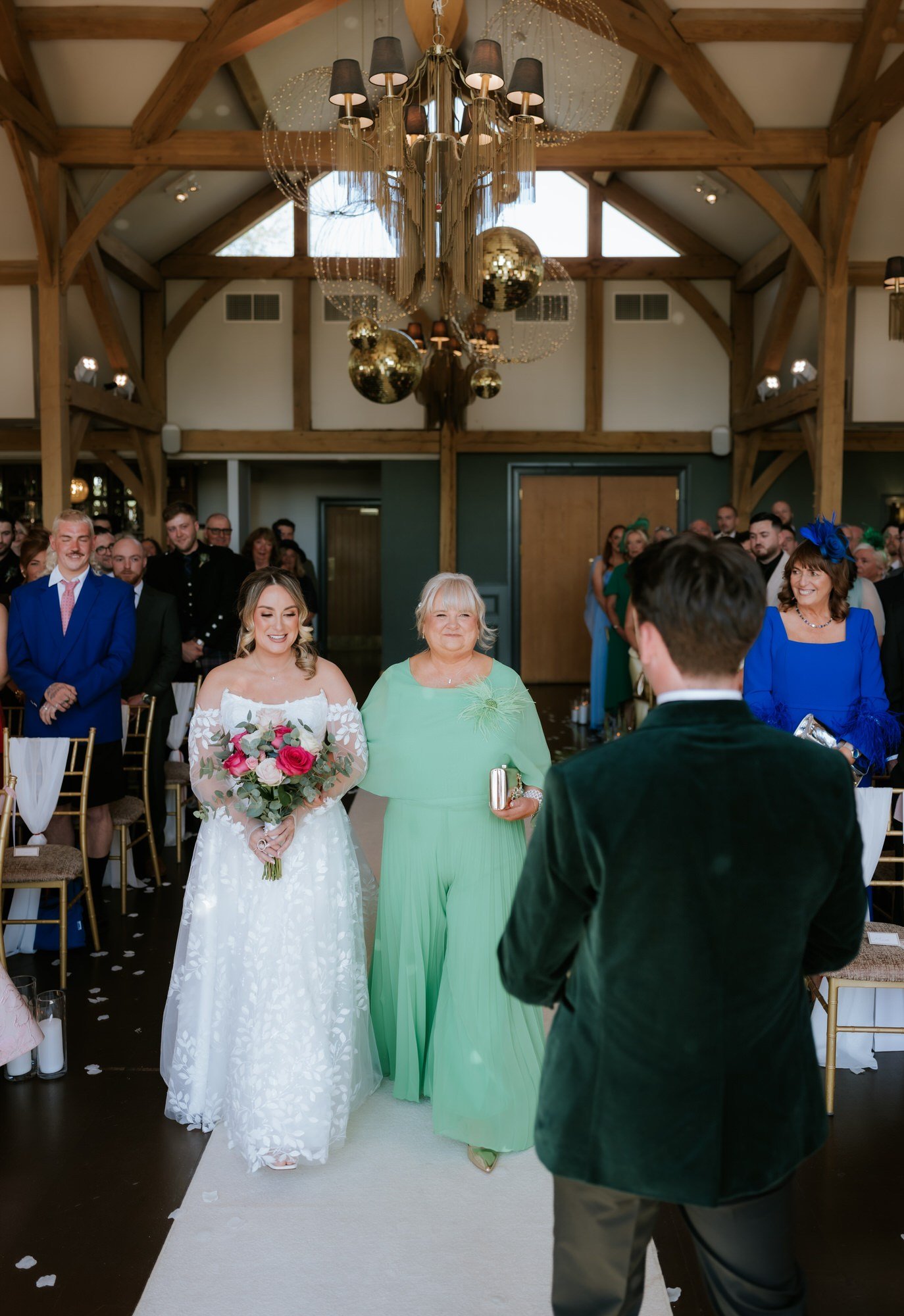 Ciara and her mum walking down the aisle towards Jonathon.