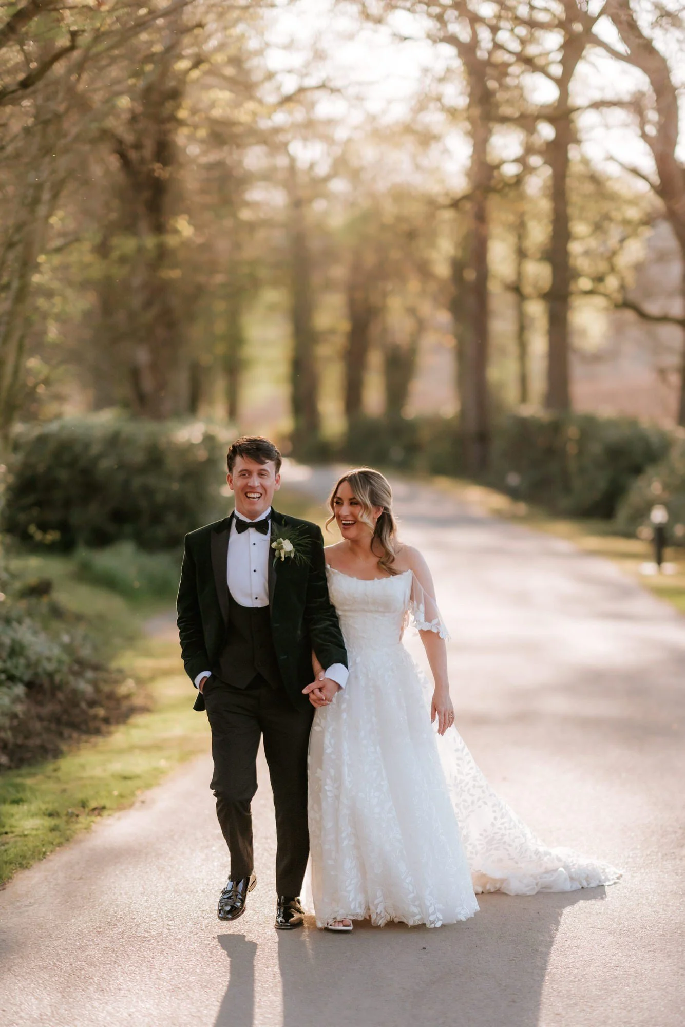 Ciara and Jonathon walking hand in hand through the evening sunshine.