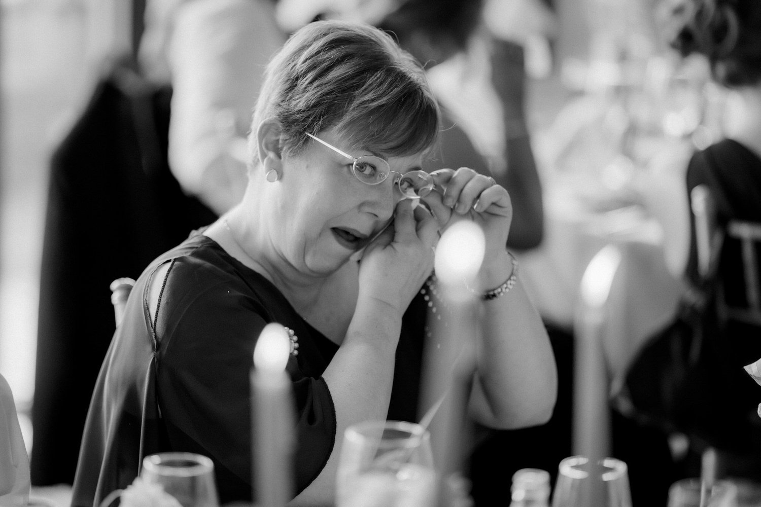 A guest wiping away a tear during the wedding breakfast.
