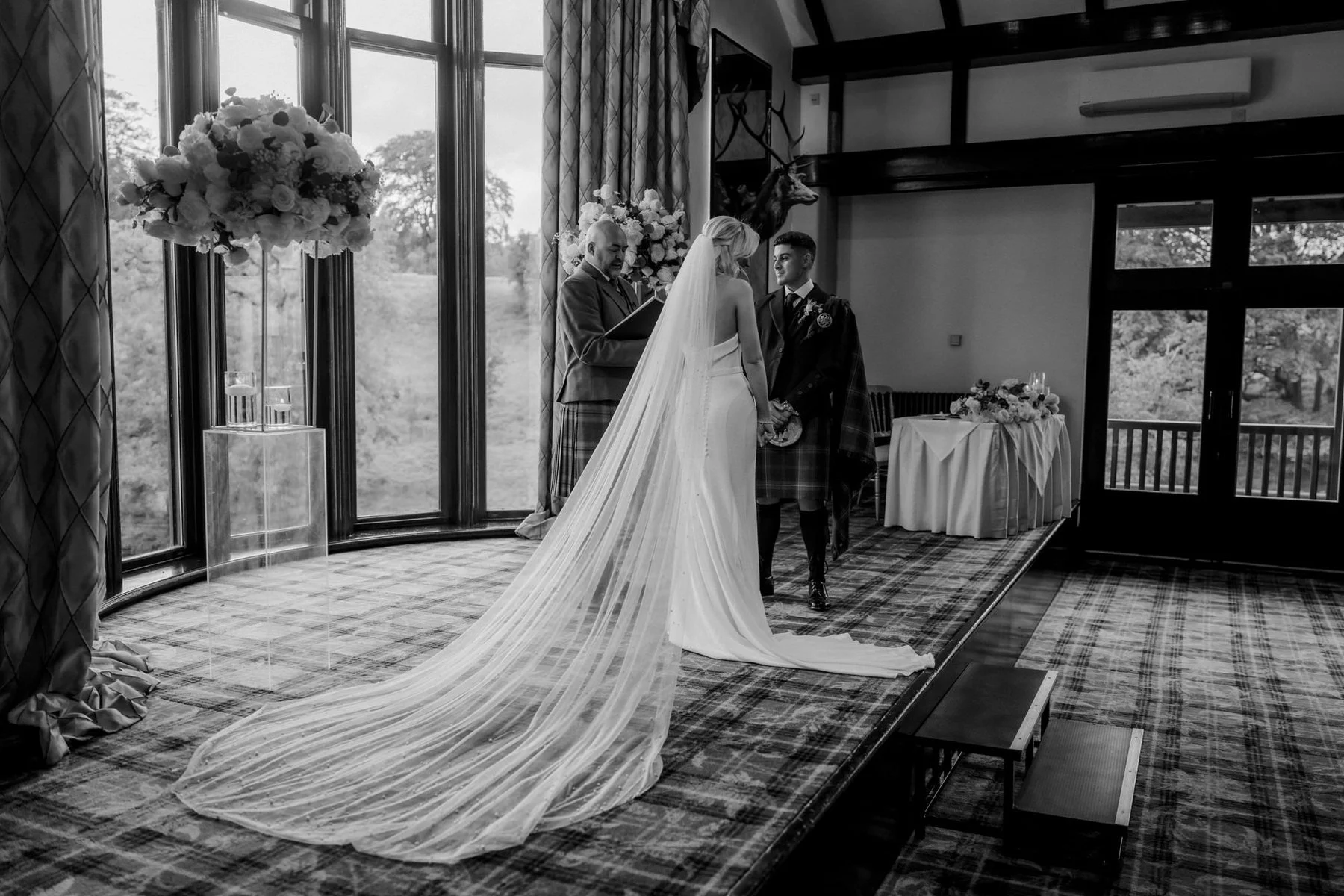 Black-and-white view of Lauren’s long veil as she stands beside Zen during the ceremony.