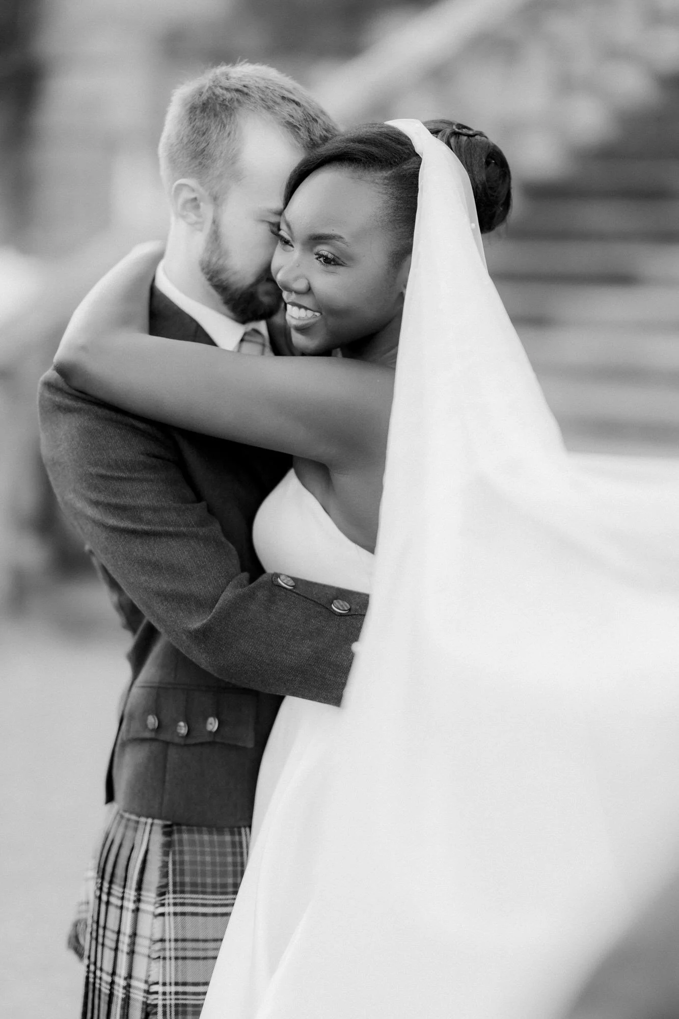 A close black and white portrait of Kuda and Jamie embracing.