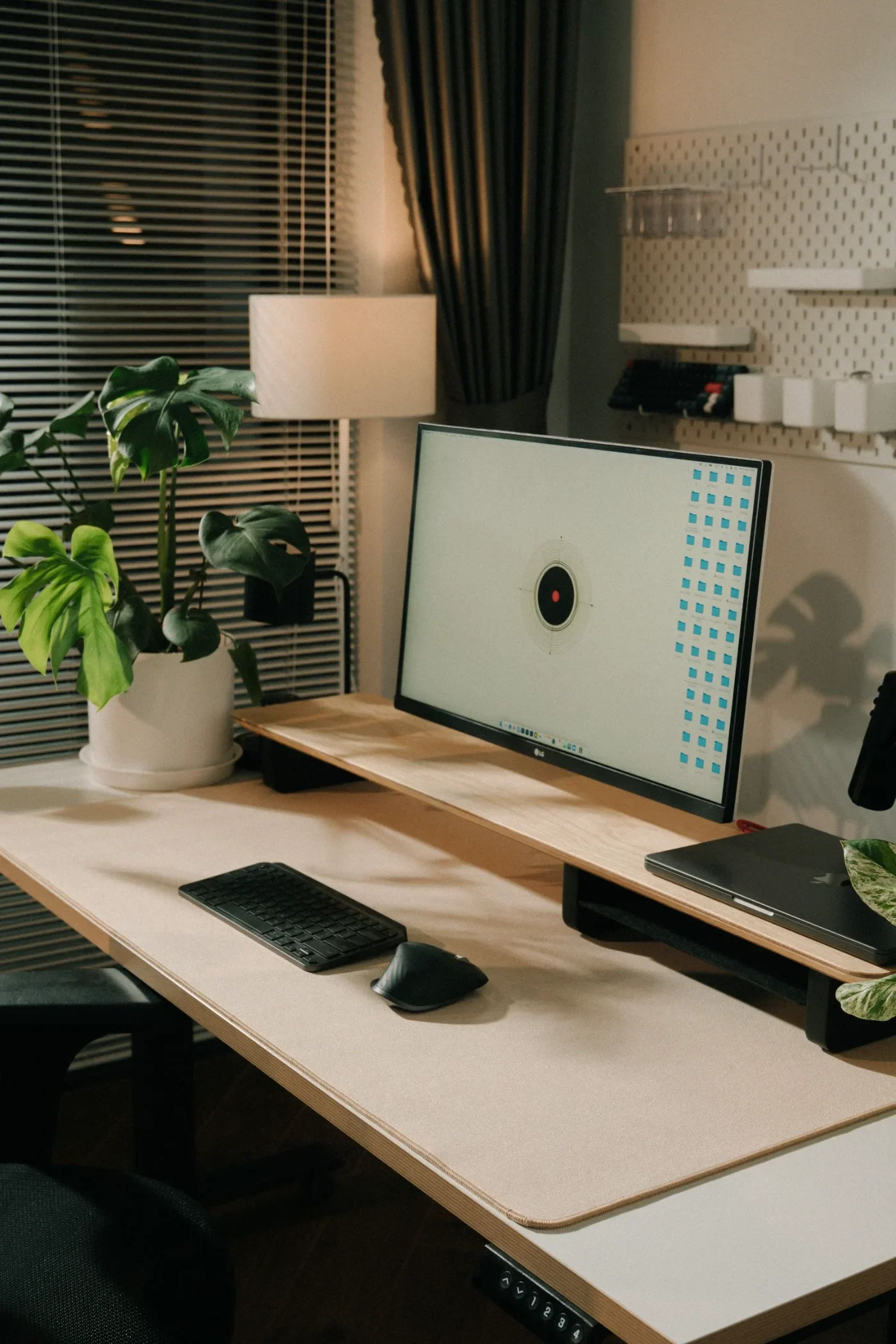 A desktop computer and keyboard sit in a warmly lit home office.