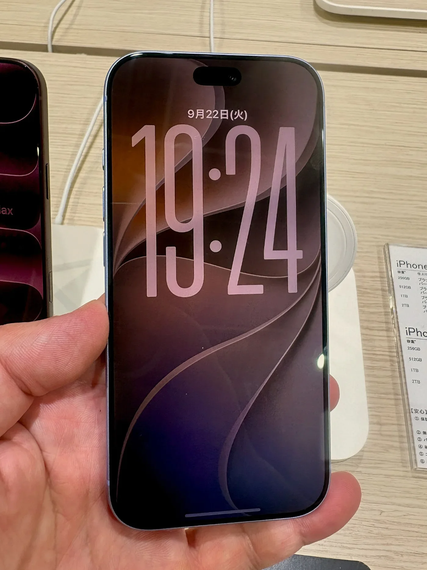 A hand holds an iPhone 18 Pro on a retail display.