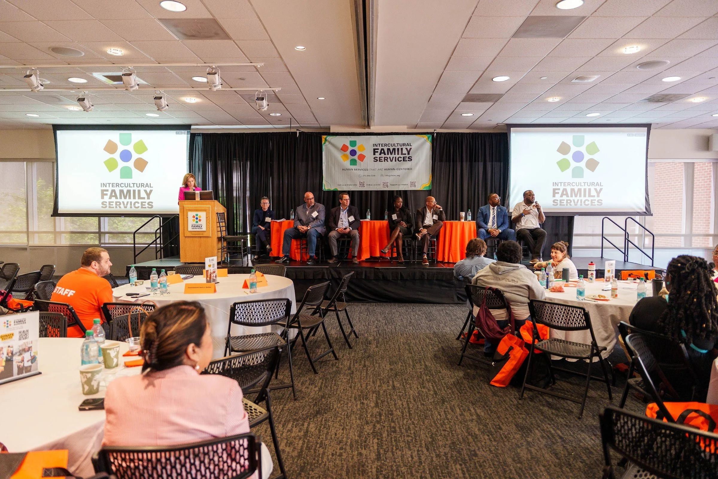 A session room set with round tables for small group discussion