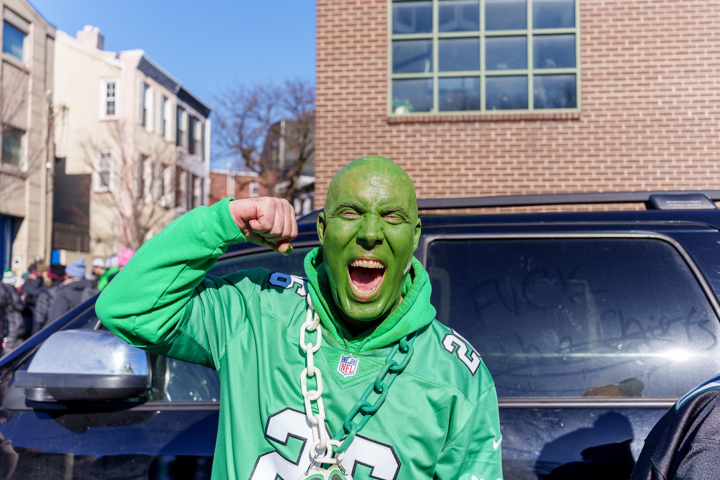 Fan in green face paint celebrating on the parade route