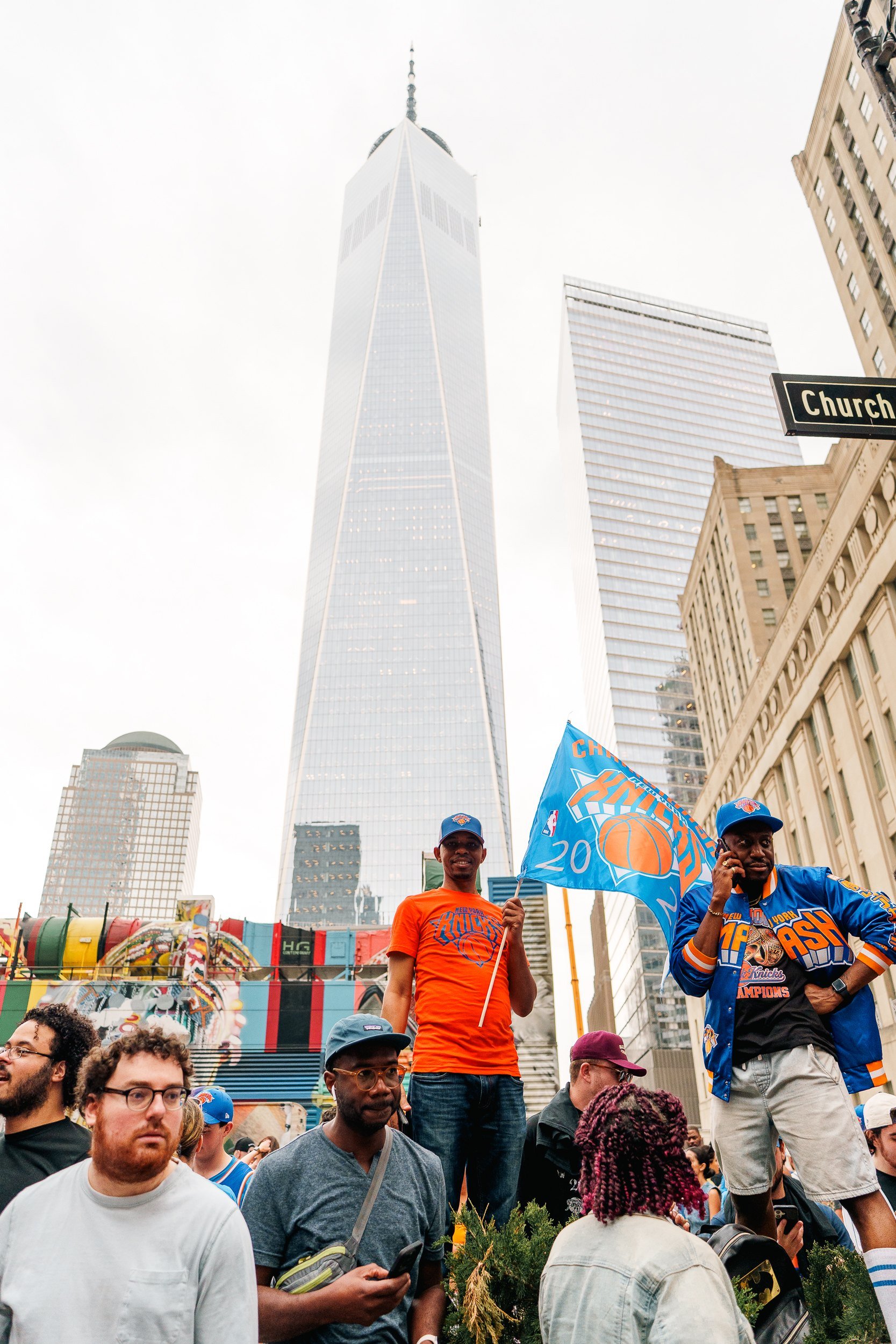 A fan with a Knicks flag beneath One World Trade Center